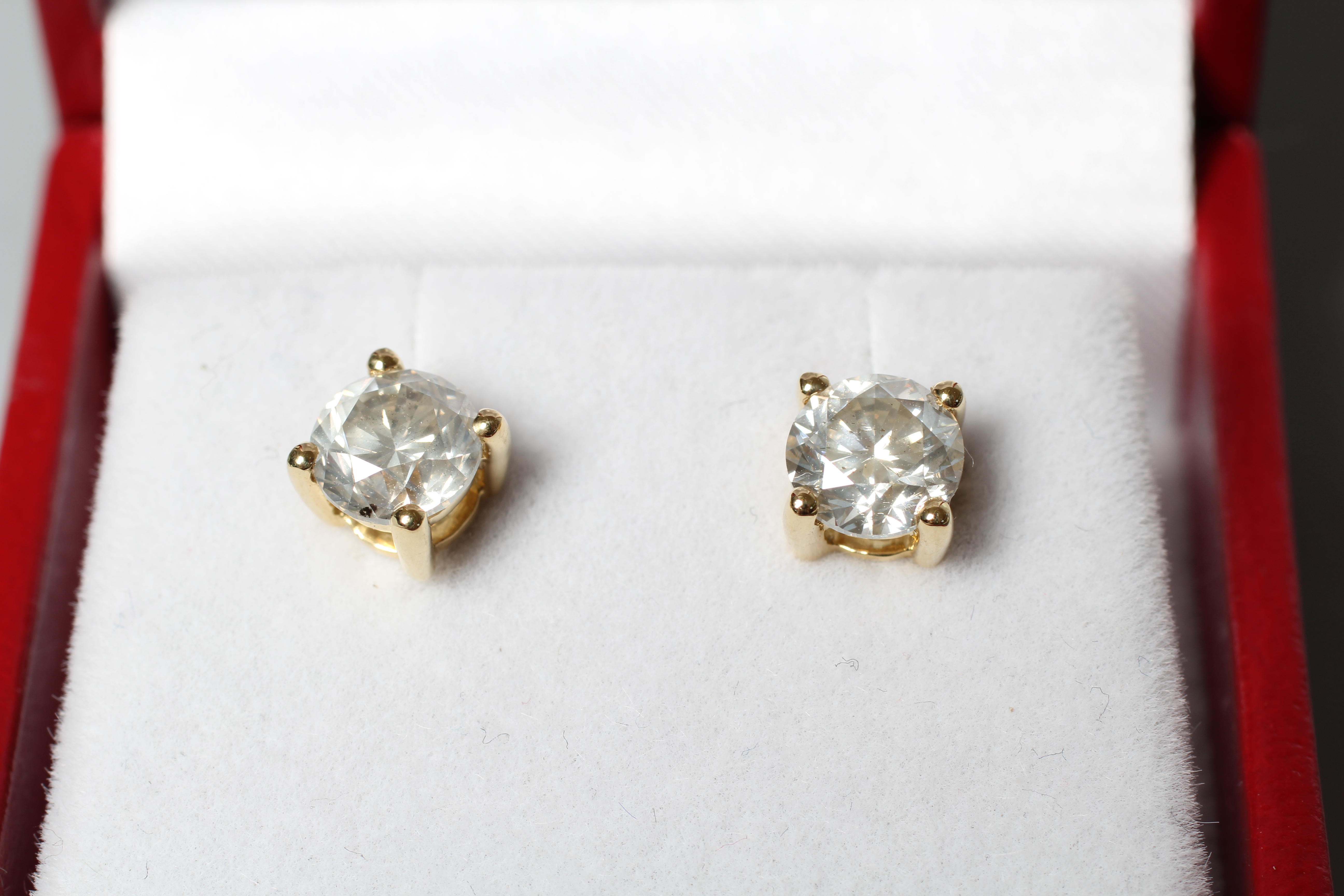 A PAIR OF DIAMOND SOLITAIRE EAR STUDS, each brilliant stone claw set to plain 18ct gold posts and Image