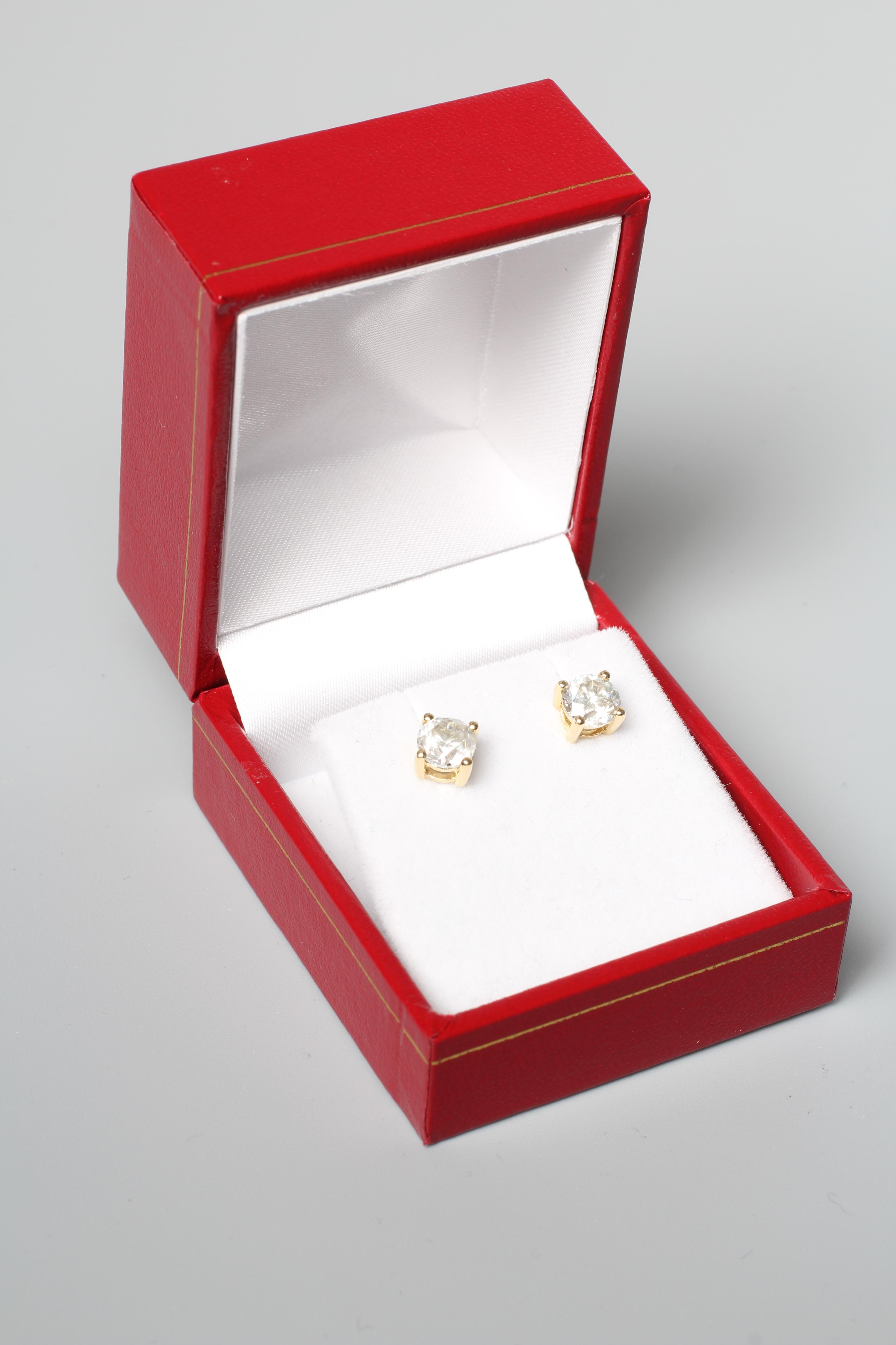 A PAIR OF DIAMOND SOLITAIRE EAR STUDS, each brilliant stone claw set to plain 18ct gold posts and Image