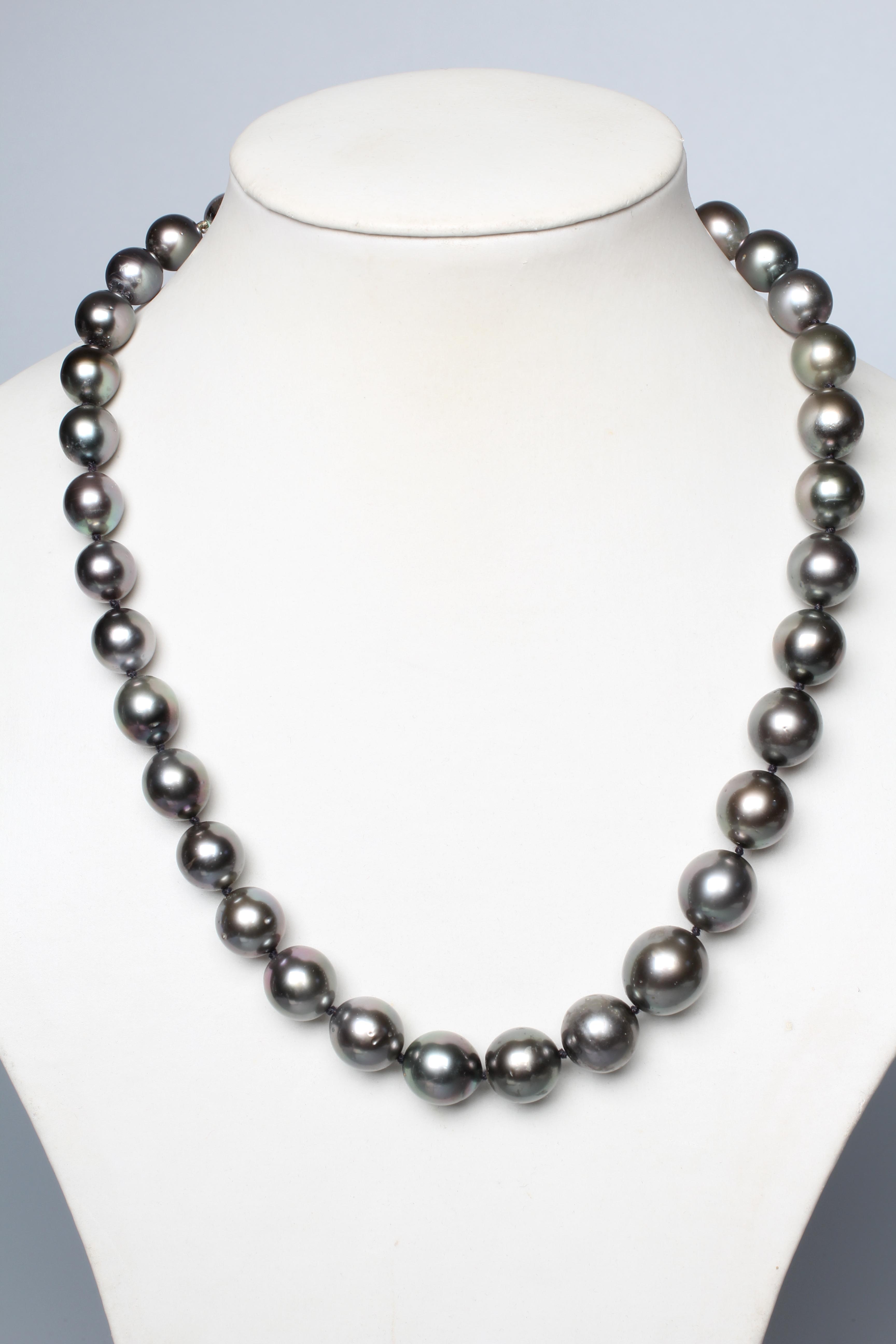 A SINGLE STRING OF BLACK TAHITIAN CULTURED PEARLS, the thirty six pearls with a white ball clasp Image