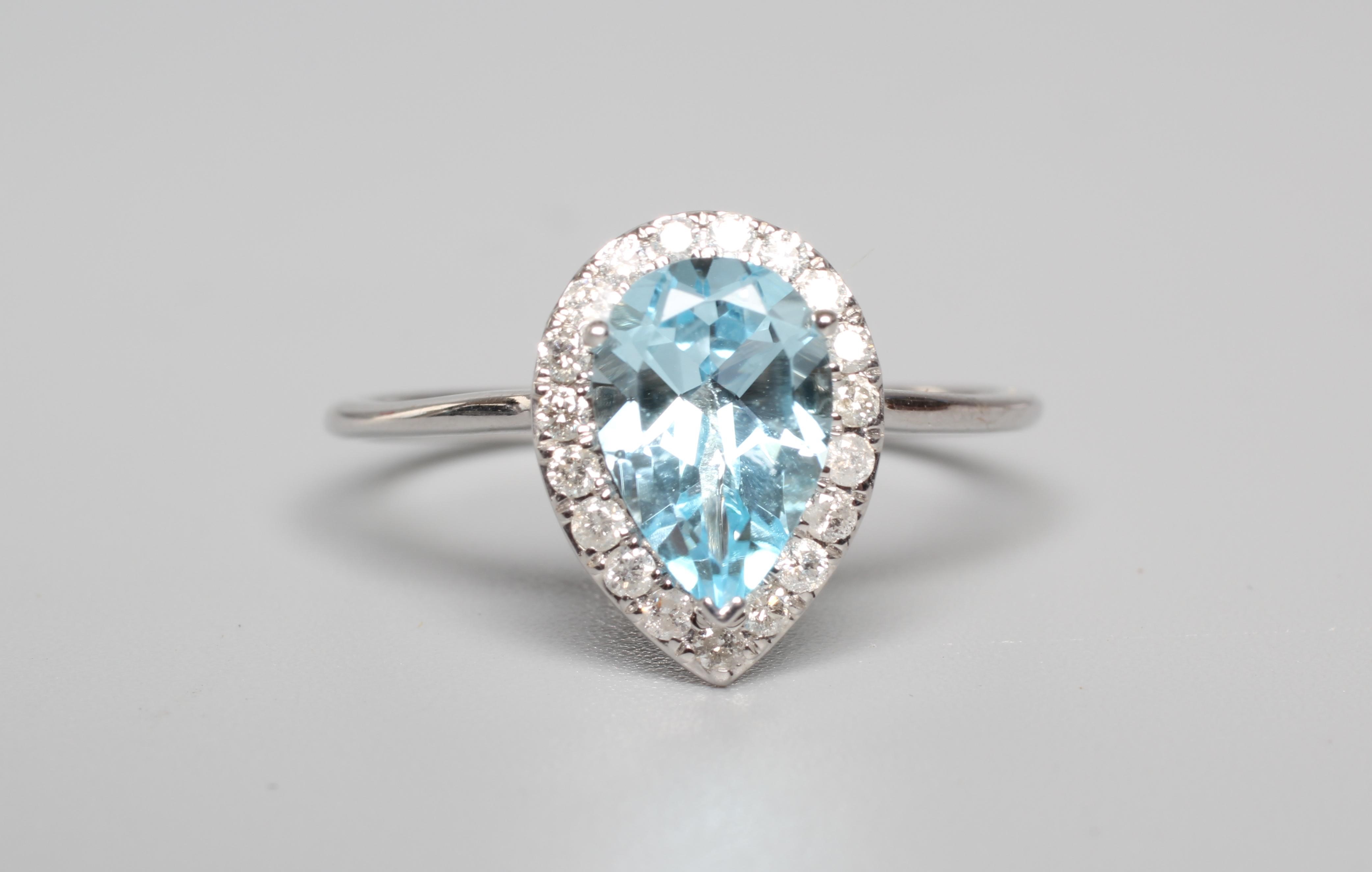A BLUE TOPAZ AND DIAMOND CLUSTER RING, the pear shaped facet cut topaz claw set to a border of Image