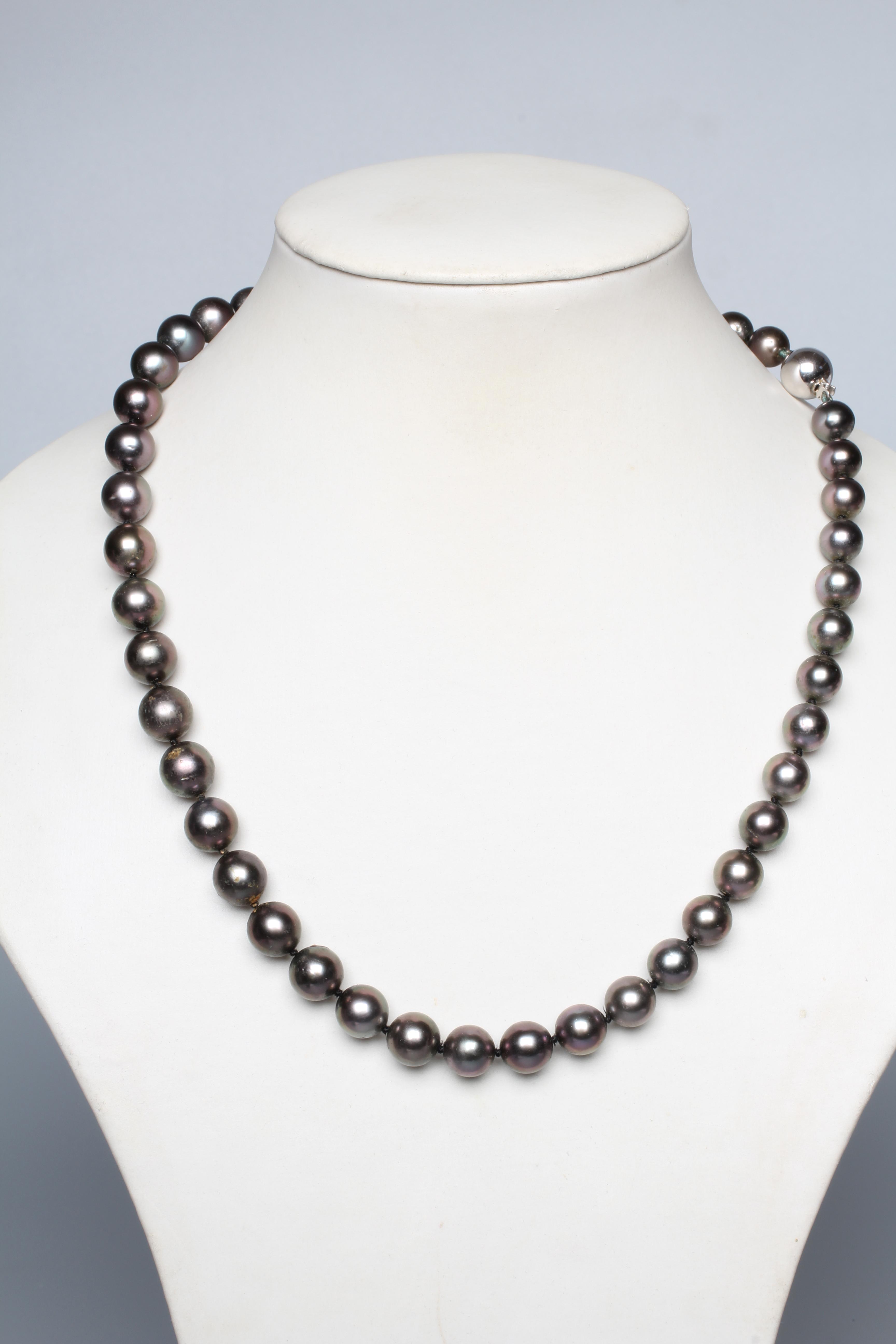 A SINGLE STRING OF BLACK TAHITIAN CULTURED PEARLS, the forty seven pearls with a white ball clasp Image