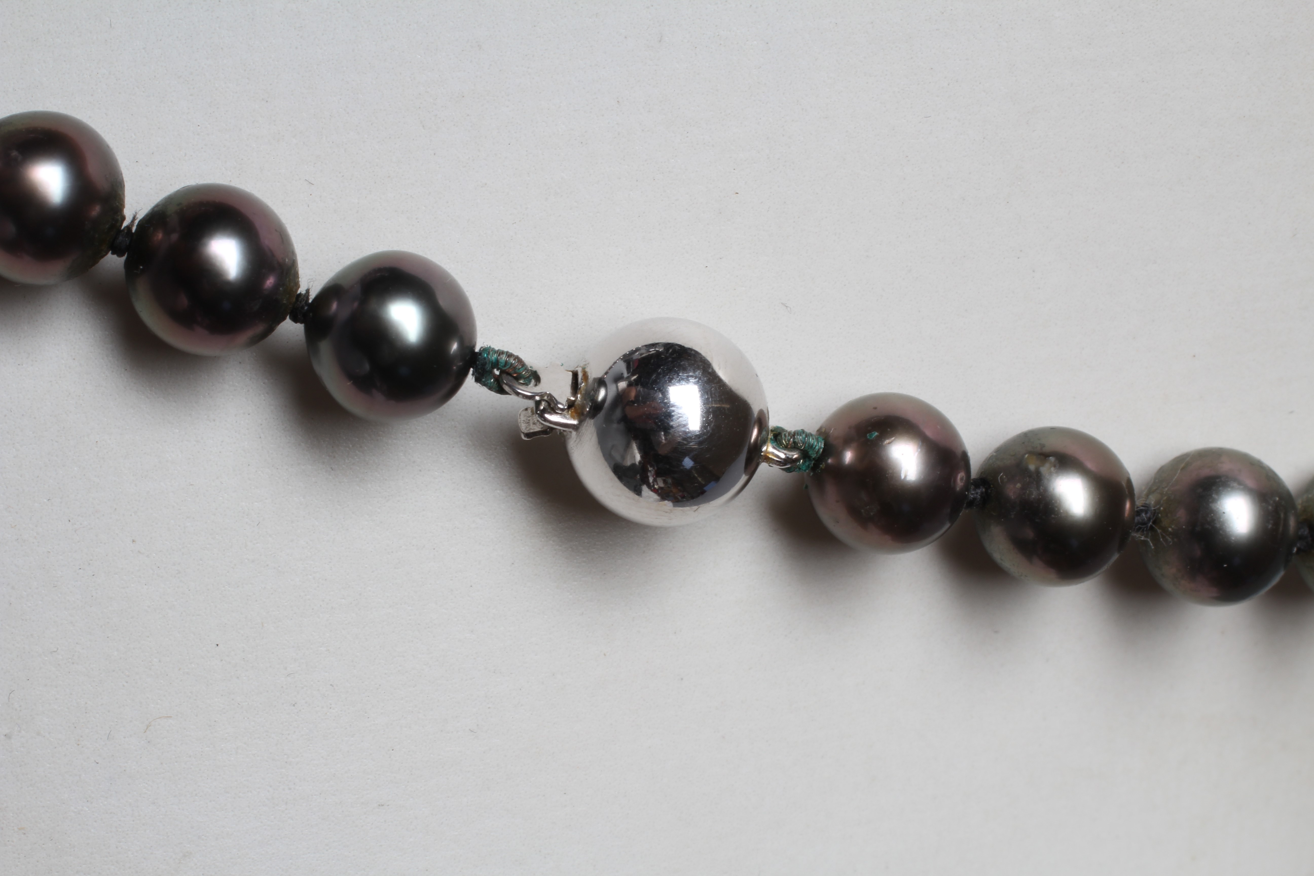 A SINGLE STRING OF BLACK TAHITIAN CULTURED PEARLS, the forty seven pearls with a white ball clasp Image