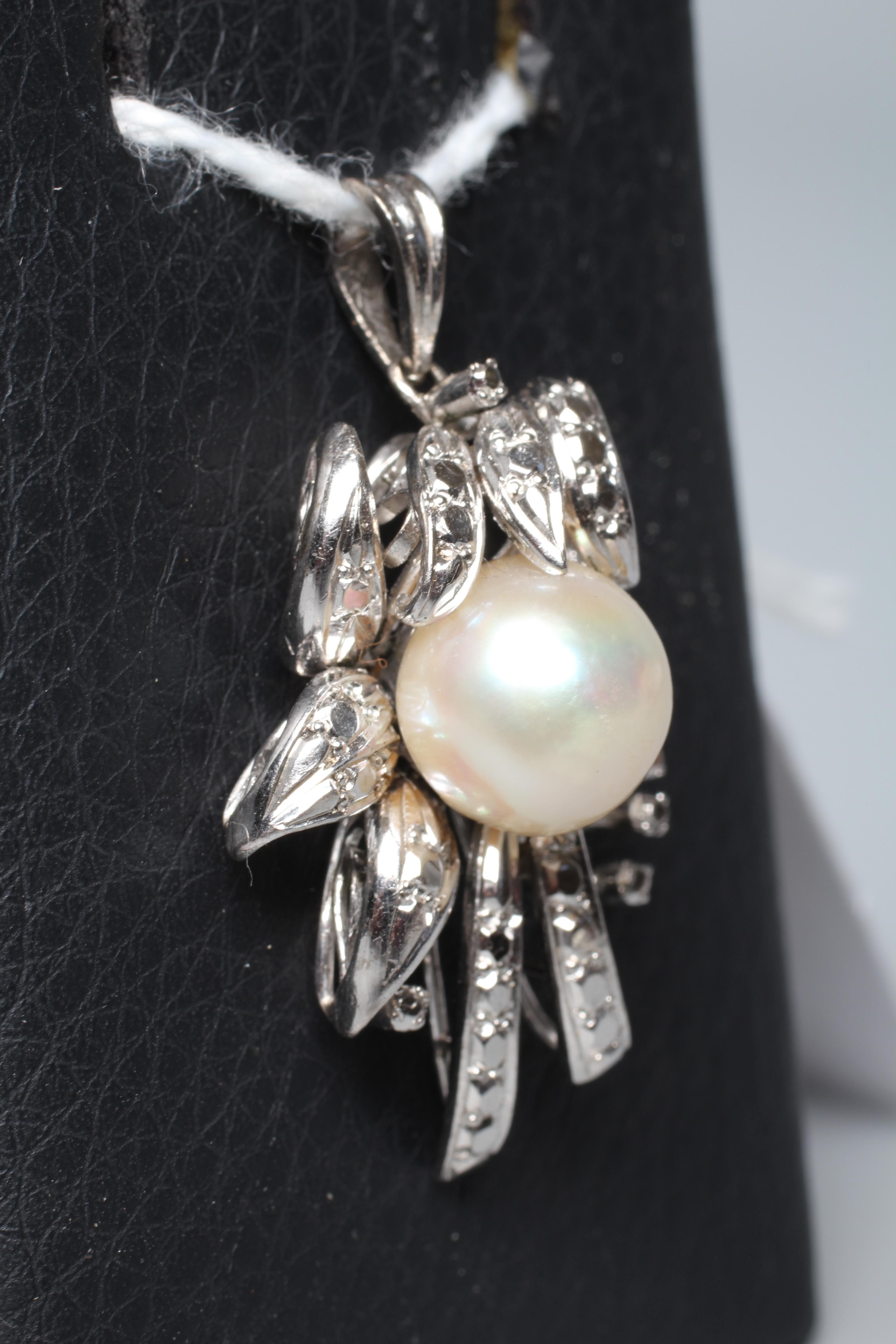 AN ABSTRACT FLOWER SPRAY PENDANT, the central cultured pearl peg set to a white frame to imitate Image