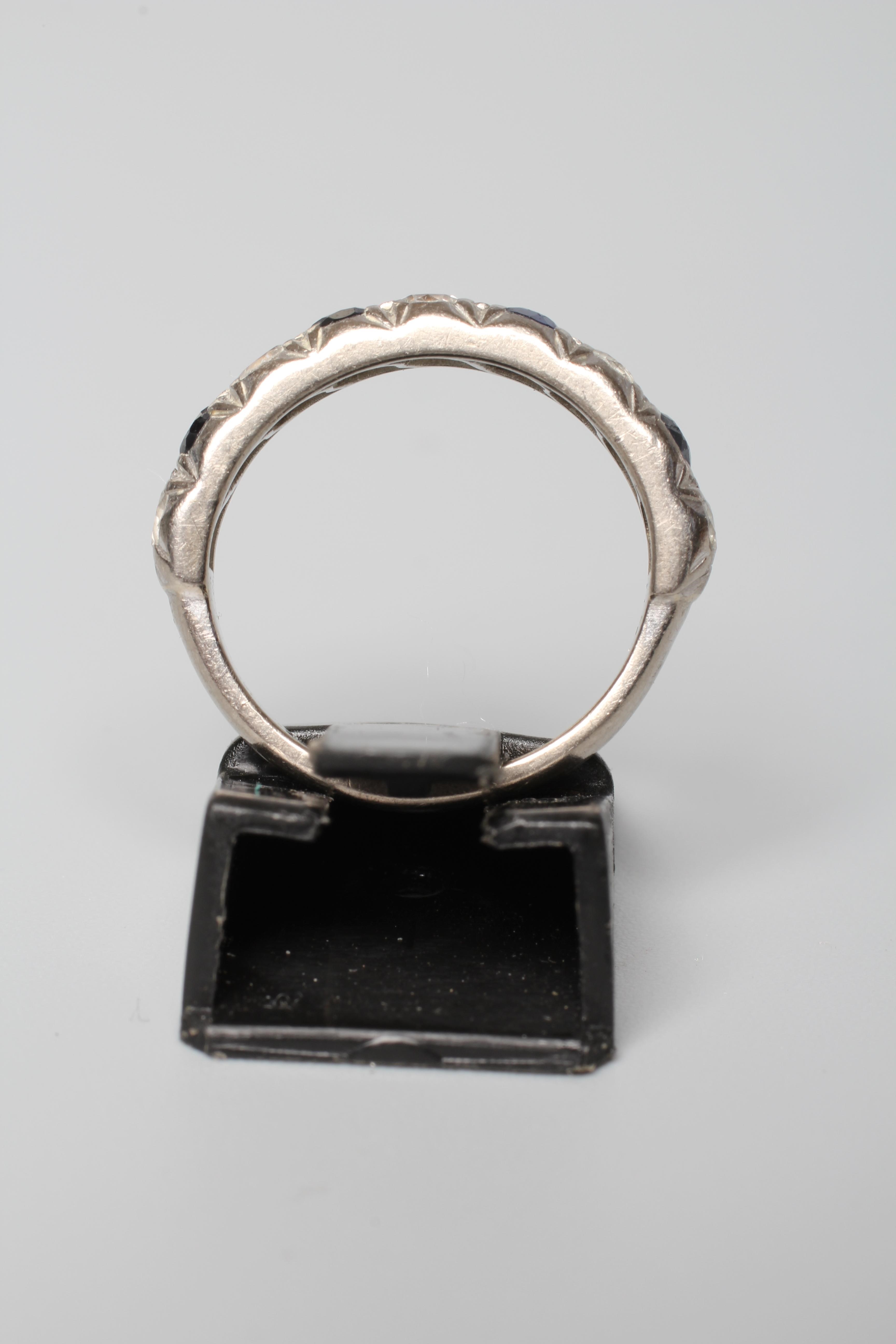 A NINE STONE SAPPHIRE AND DIAMOND HALF HOOP ETERNITY RING, the four sapphires and five diamonds in a Image