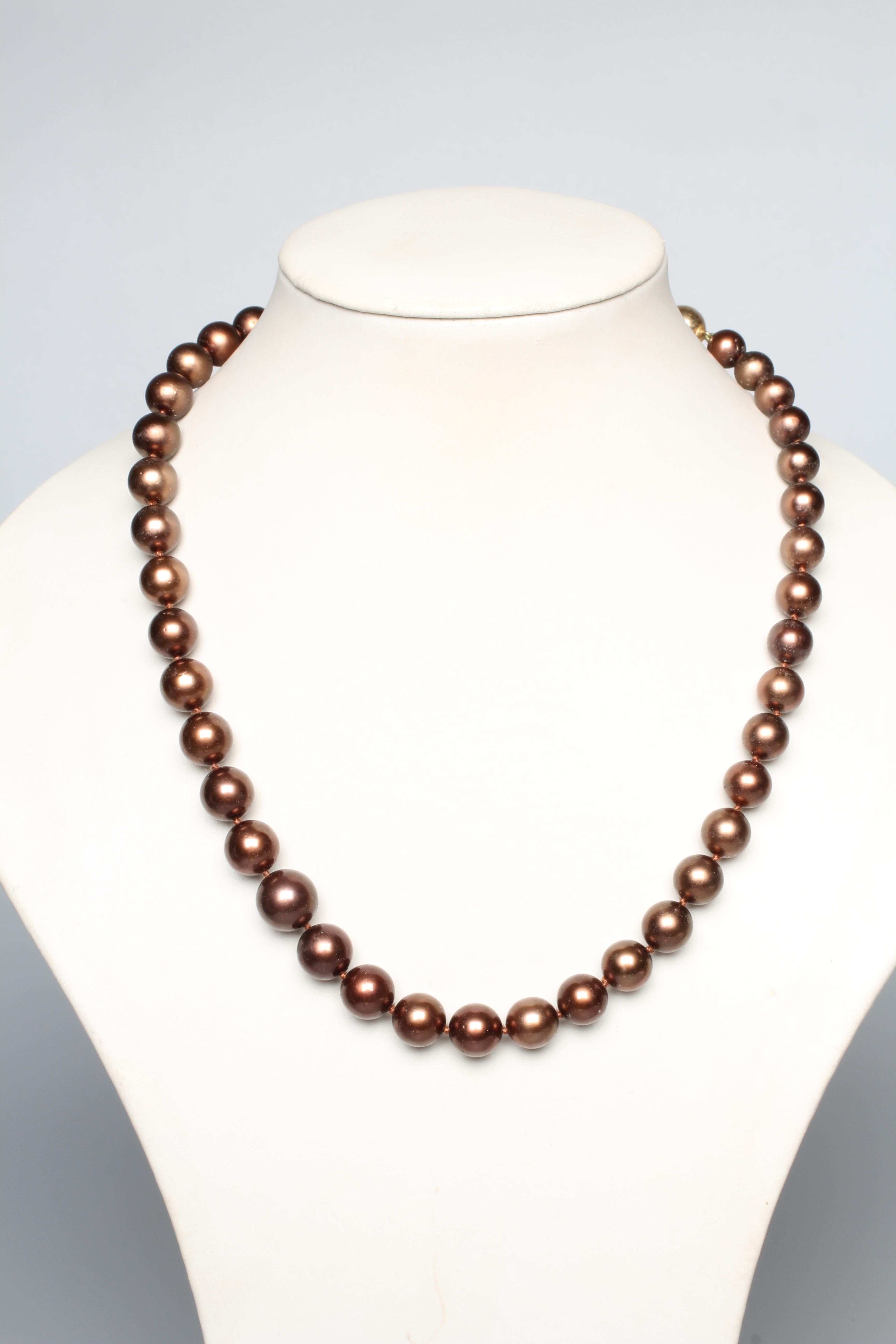 A SINGLE STRING OF BRONZE TAHITIAN CULTURED PEARLS, the forty five graduated pearls with a yellow Image