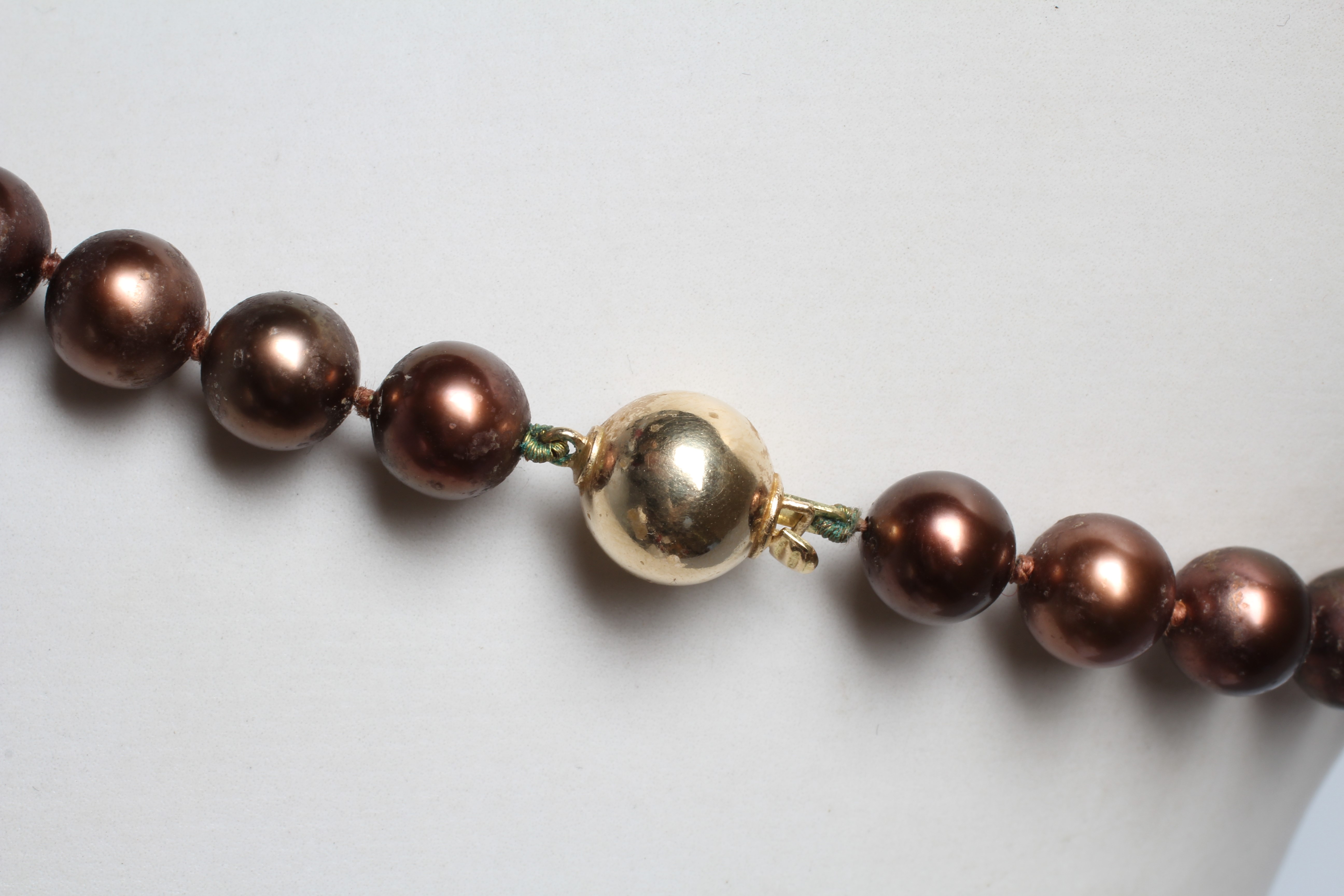 A SINGLE STRING OF BRONZE TAHITIAN CULTURED PEARLS, the forty five graduated pearls with a yellow Image