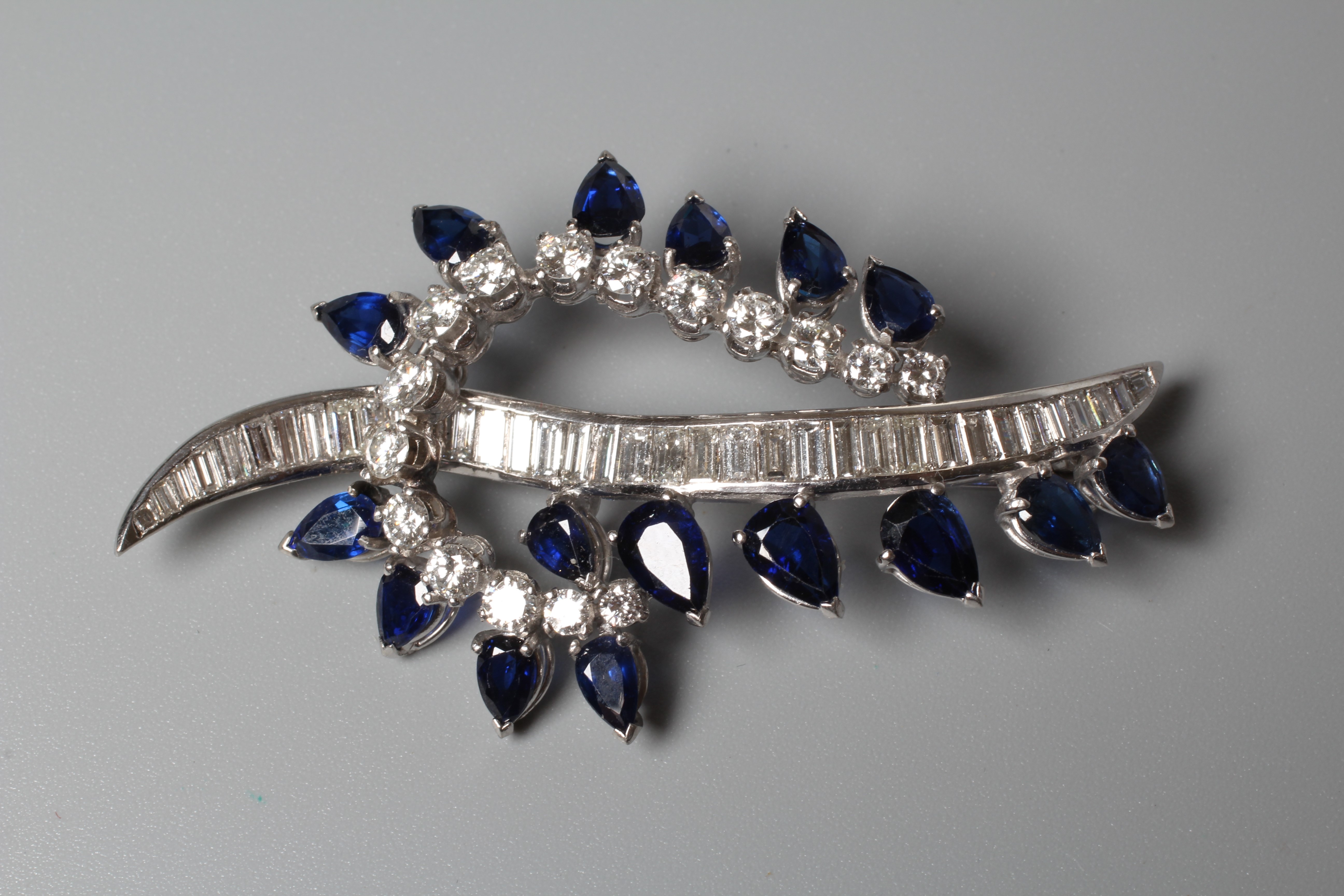 A SAPPHIRE AND DIAMOND COCKTAIL BROOCH of abstract leaf design Image
