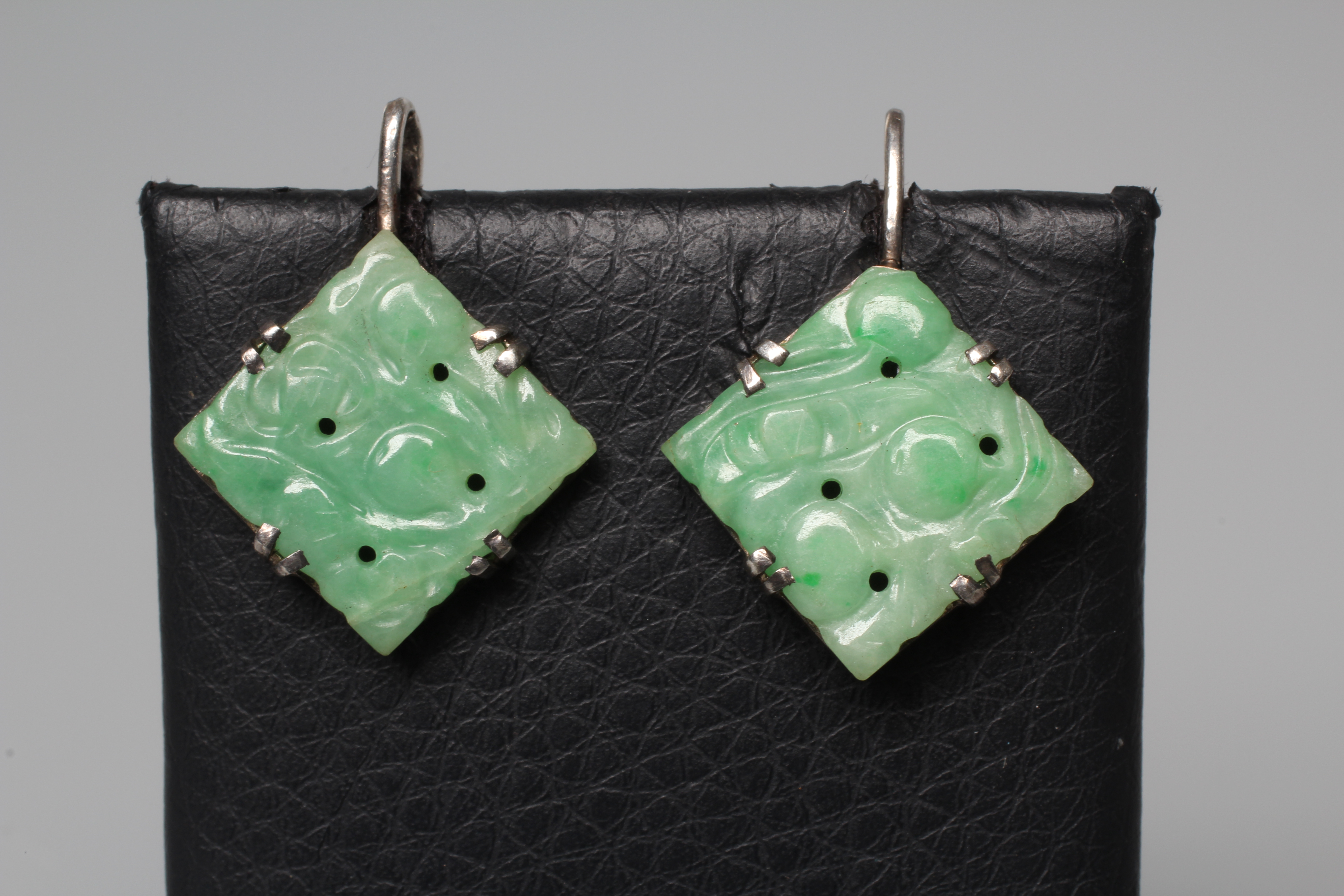 A PAIR OF CHINESE JADE EARRINGS, the flower carved square panels on unmarked white metal hooks Image