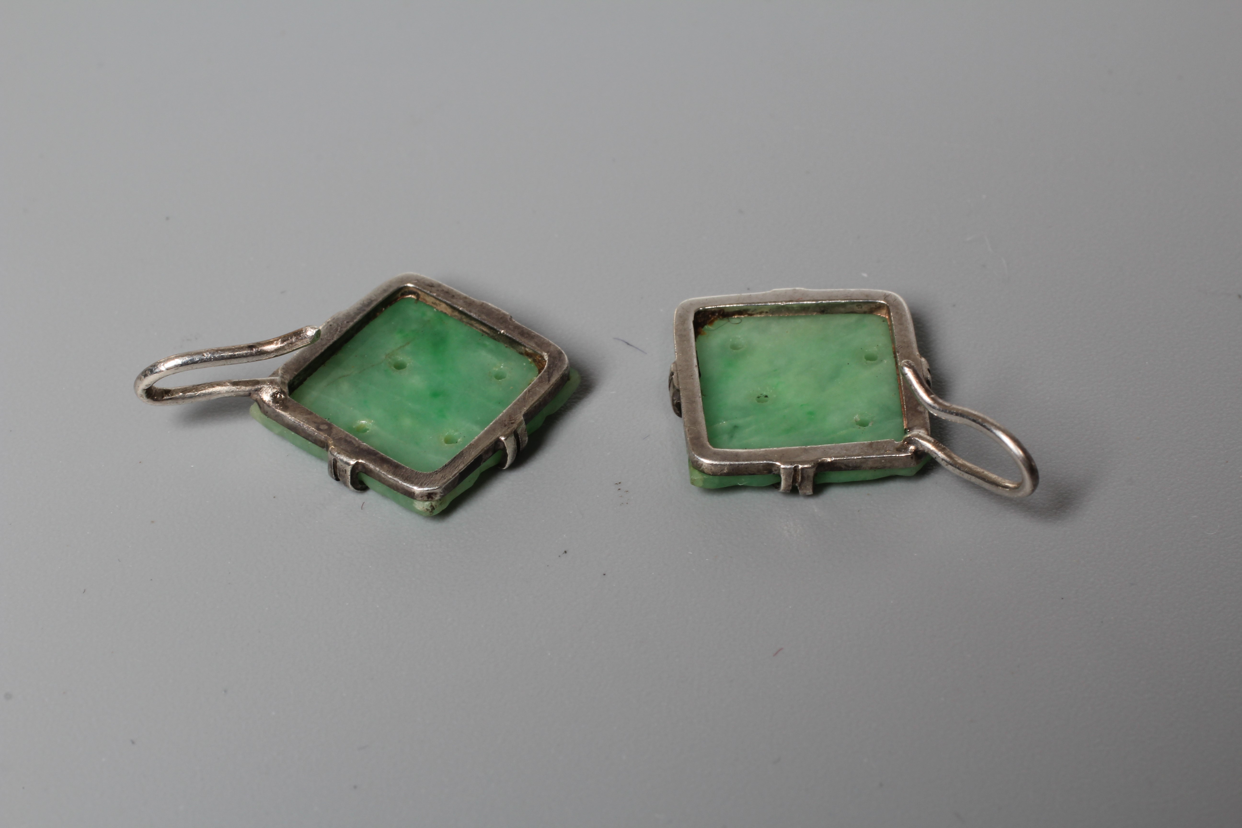 A PAIR OF CHINESE JADE EARRINGS, the flower carved square panels on unmarked white metal hooks Image