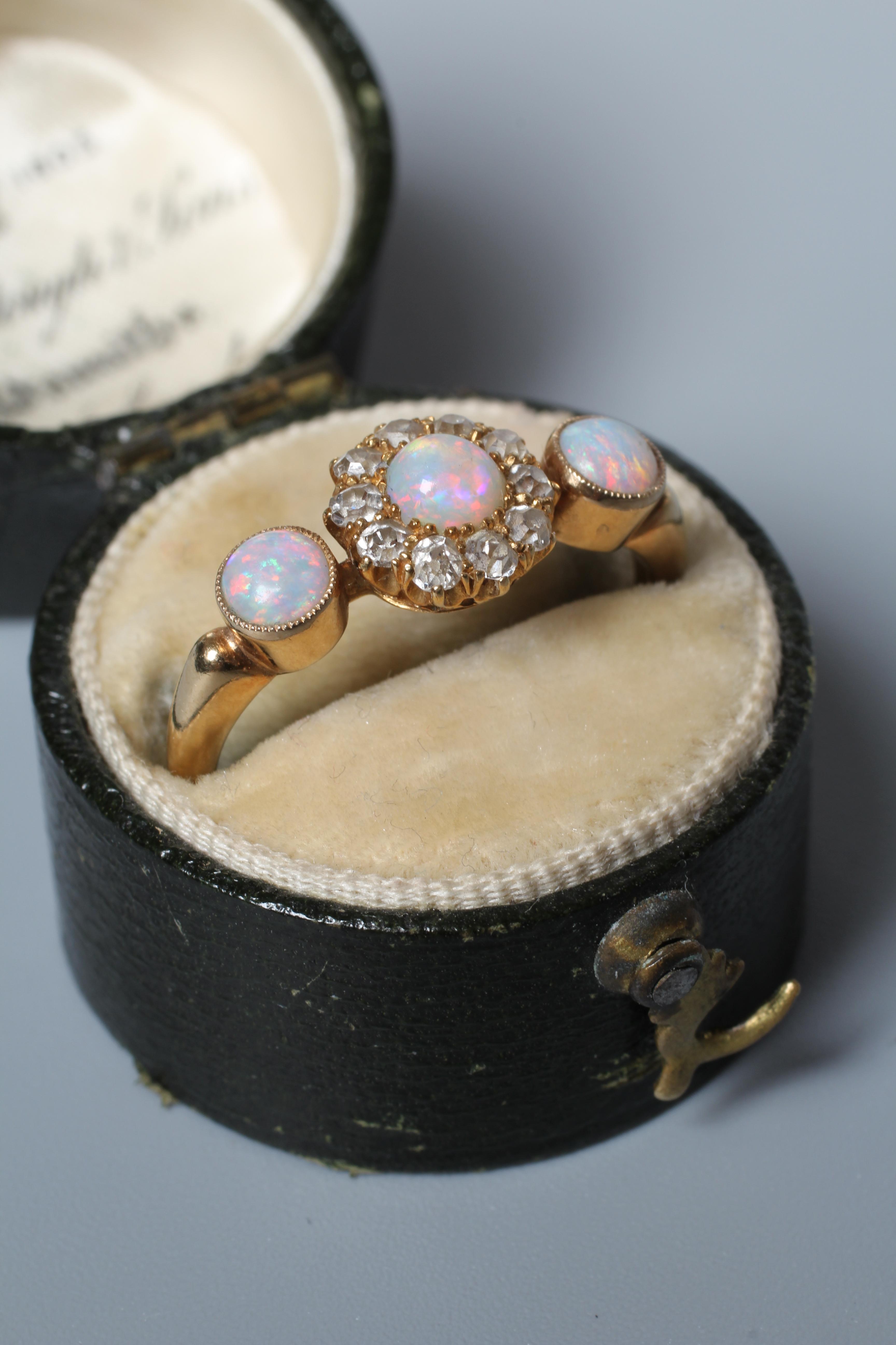 AN EDWARDIAN OPAL AND DIAMOND DRESS RING, the central cluster on a knife edge bar flanked by two Image