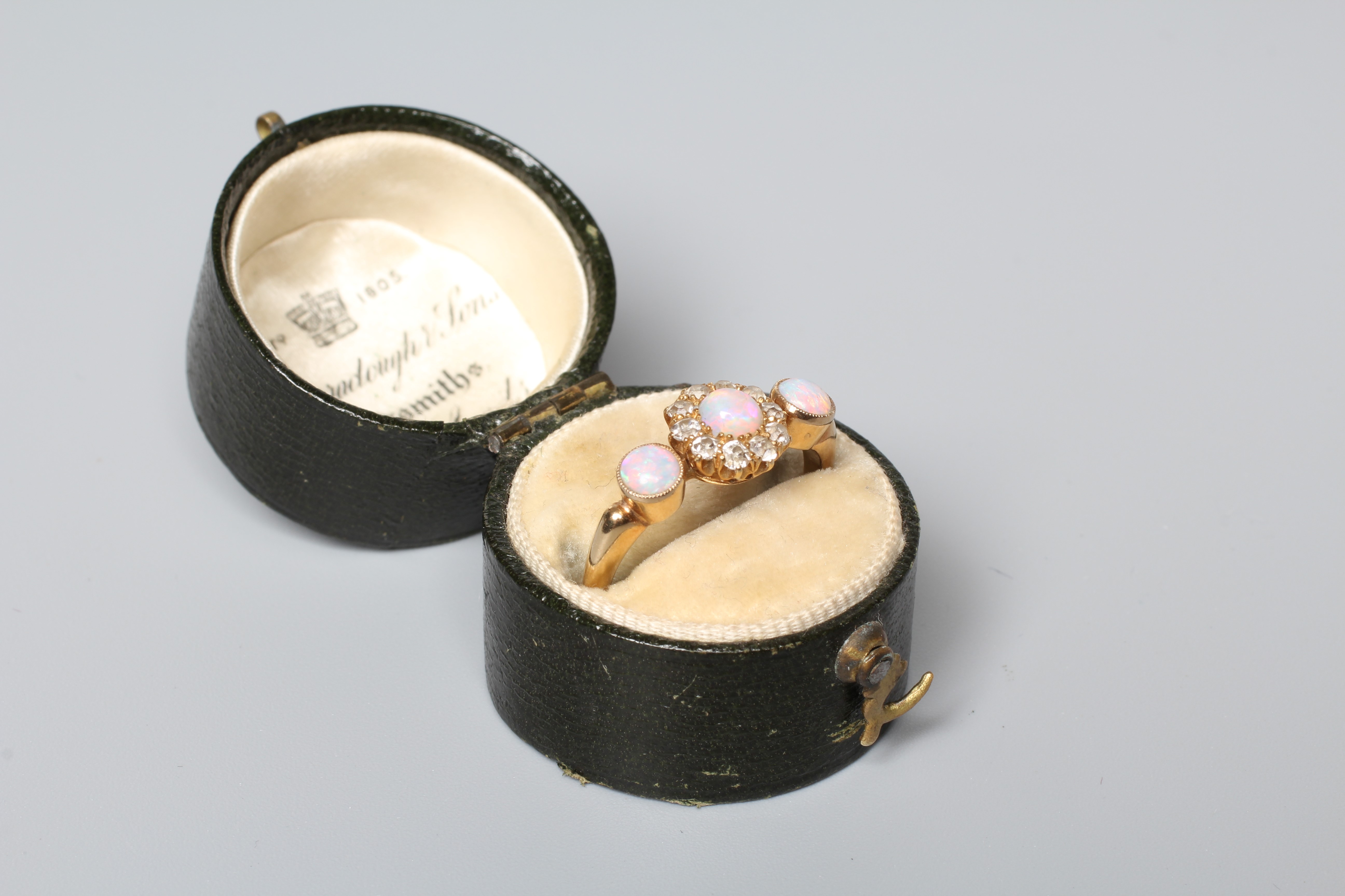 AN EDWARDIAN OPAL AND DIAMOND DRESS RING, the central cluster on a knife edge bar flanked by two Image