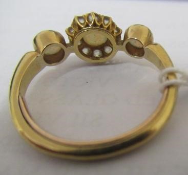 AN EDWARDIAN OPAL AND DIAMOND DRESS RING, the central cluster on a knife edge bar flanked by two Image