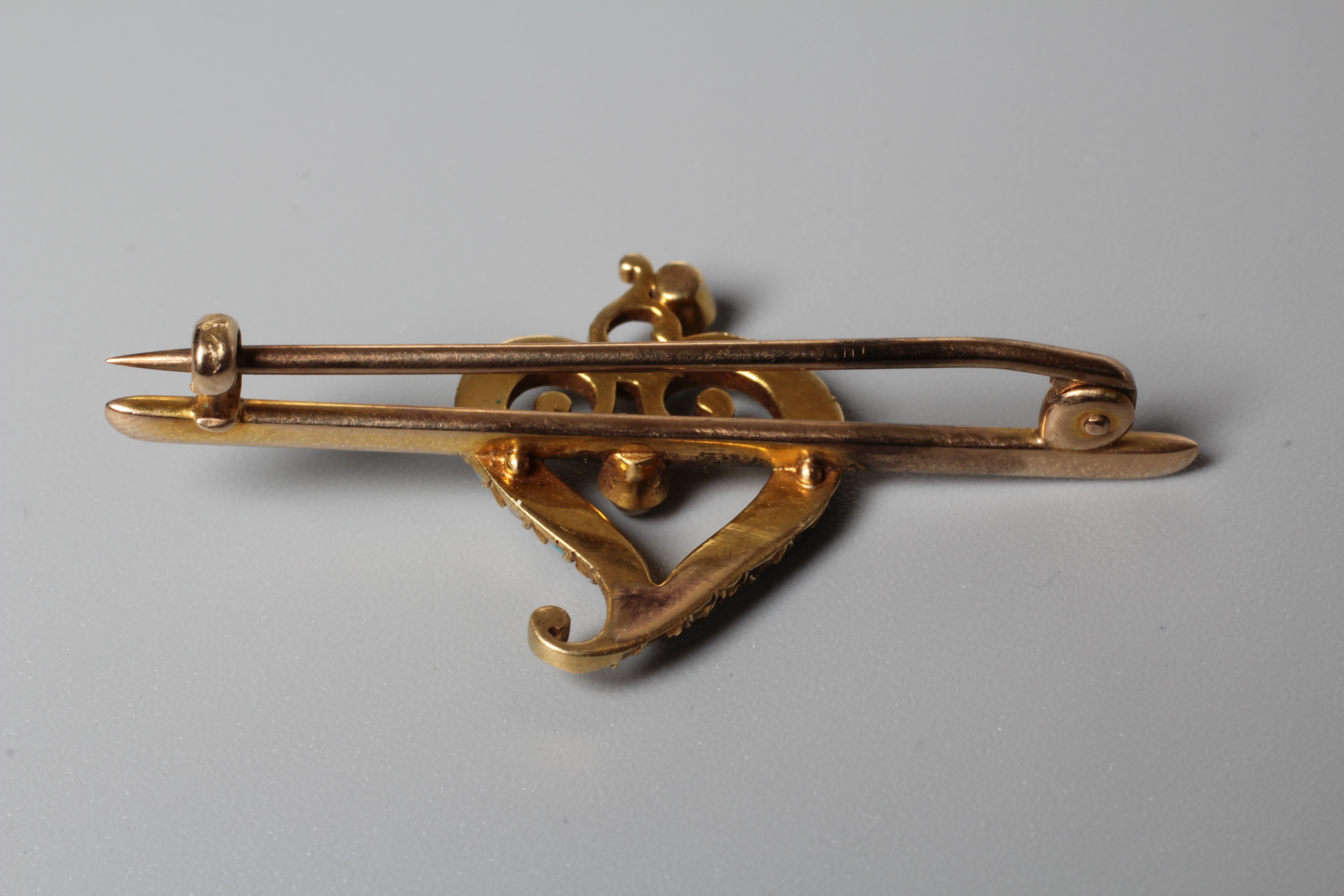 AN EDWARDIAN SEED PEARL AND TURQUOISE BAR BROOCH, the central open heart on an unmarked knife edge Image