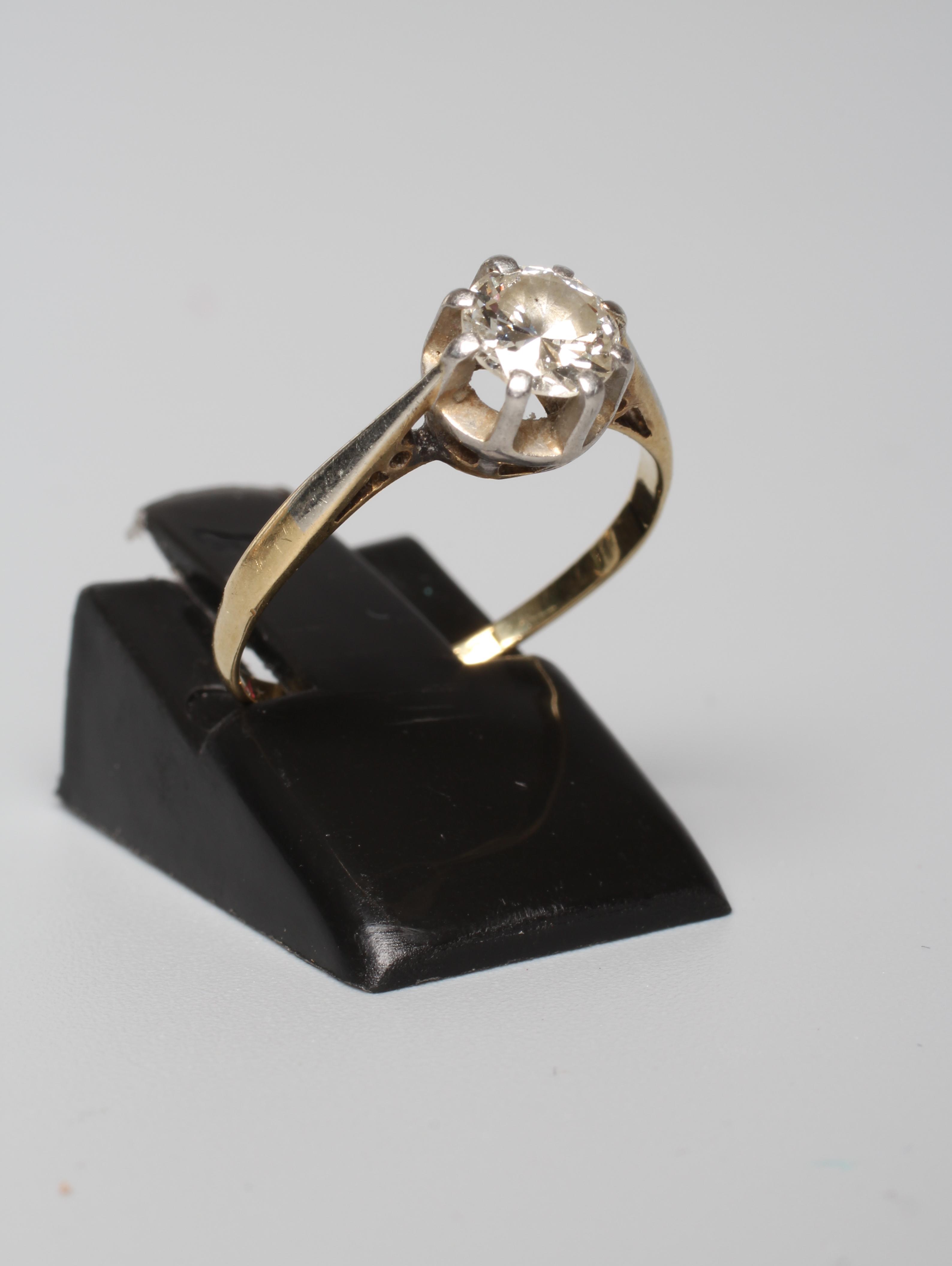A SOLITAIRE DIAMOND RING, the old cut stone of approximately 0.6cts, claw set to a white metal rim Image