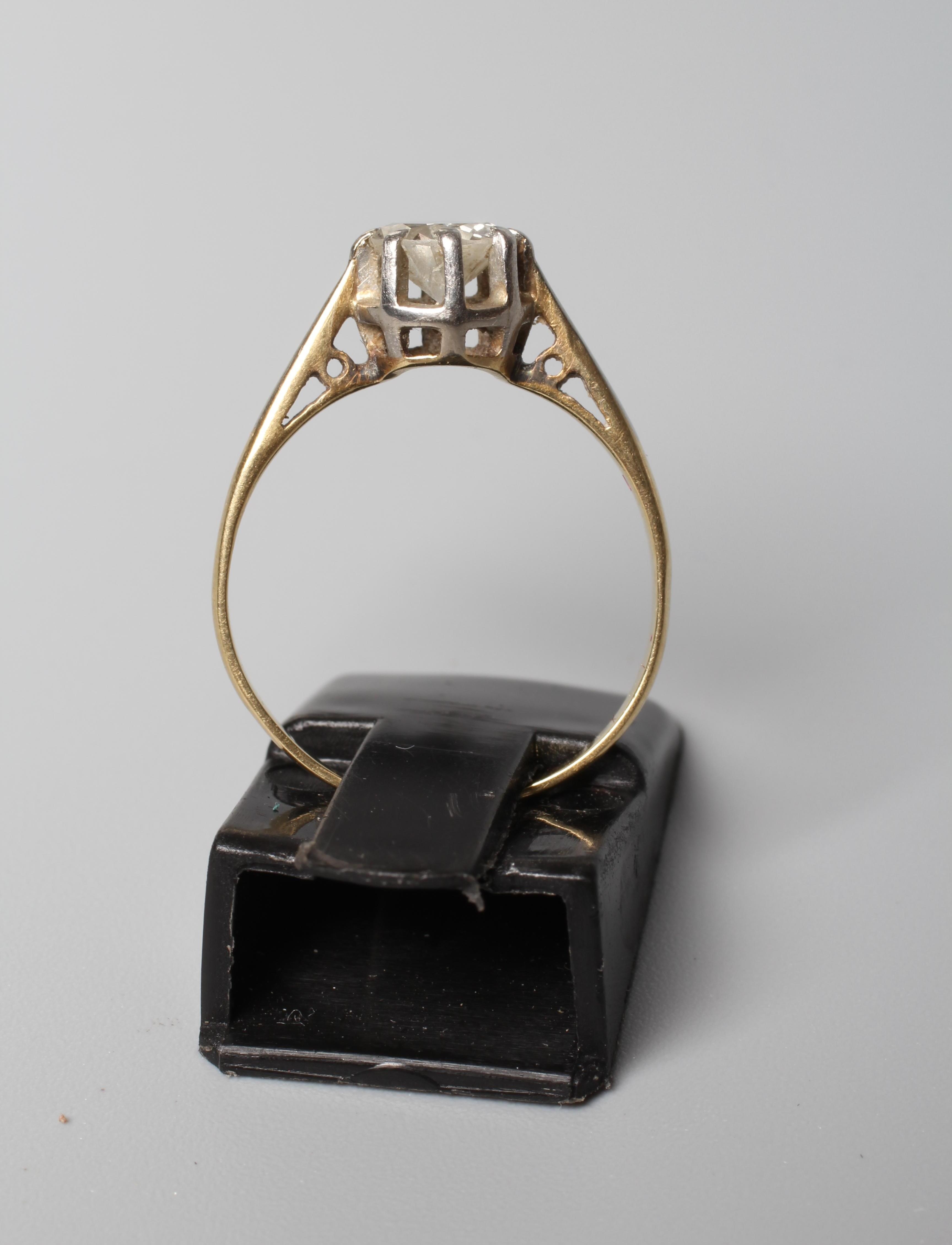 A SOLITAIRE DIAMOND RING, the old cut stone of approximately 0.6cts, claw set to a white metal rim Image