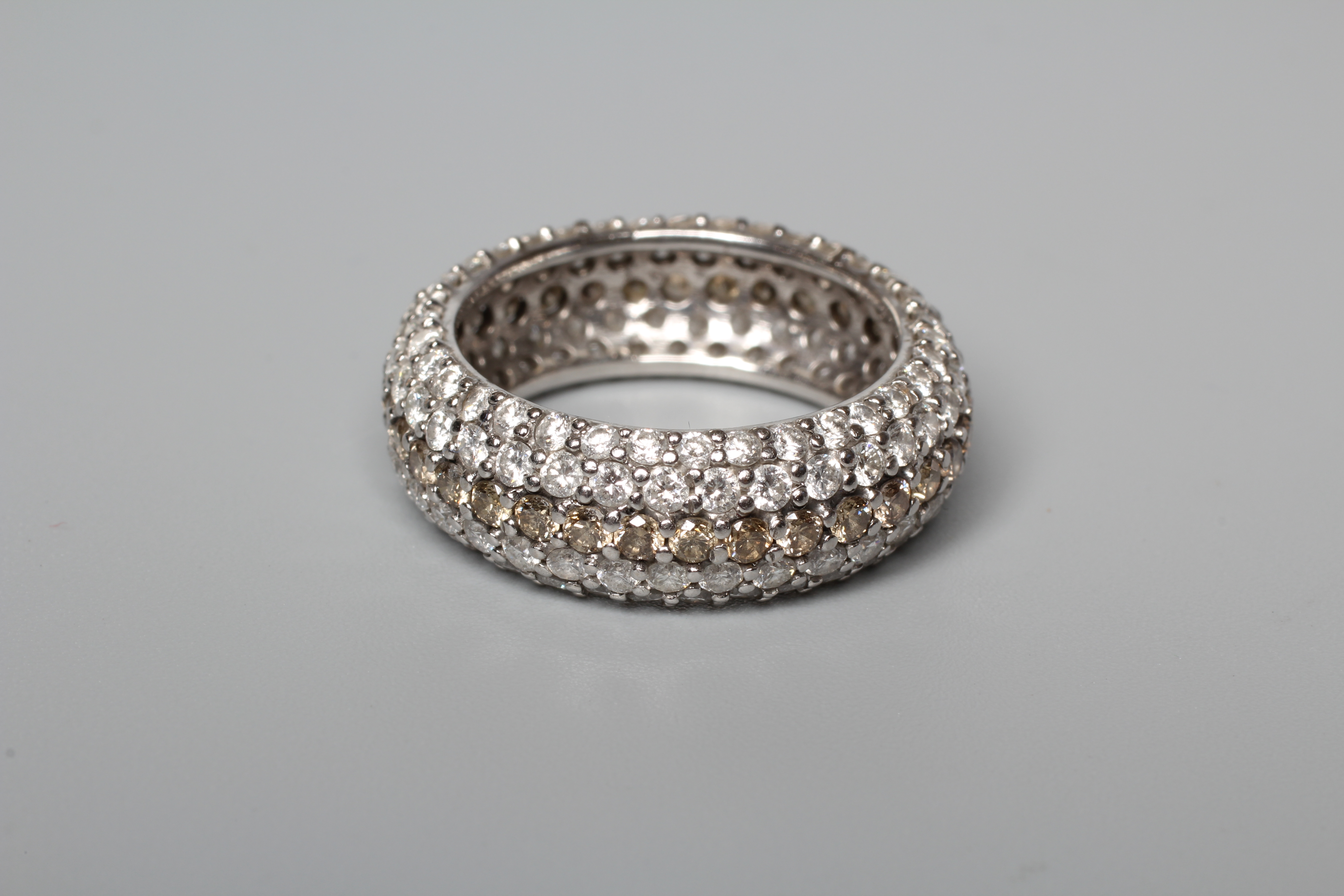 A FIVE ROW DIAMOND FULL ETERNITY DRESS RING, the central row of brown stones point set to borders of Image