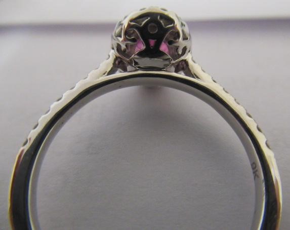 A PINK SAPPHIRE AND DIAMOND CLUSTER RING, the oval facet cut sapphire claw set to a border of small Image