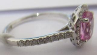 A PINK SAPPHIRE AND DIAMOND CLUSTER RING, the oval facet cut sapphire claw set to a border of small Image