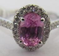A PINK SAPPHIRE AND DIAMOND CLUSTER RING, the oval facet cut sapphire claw set to a border of small Image