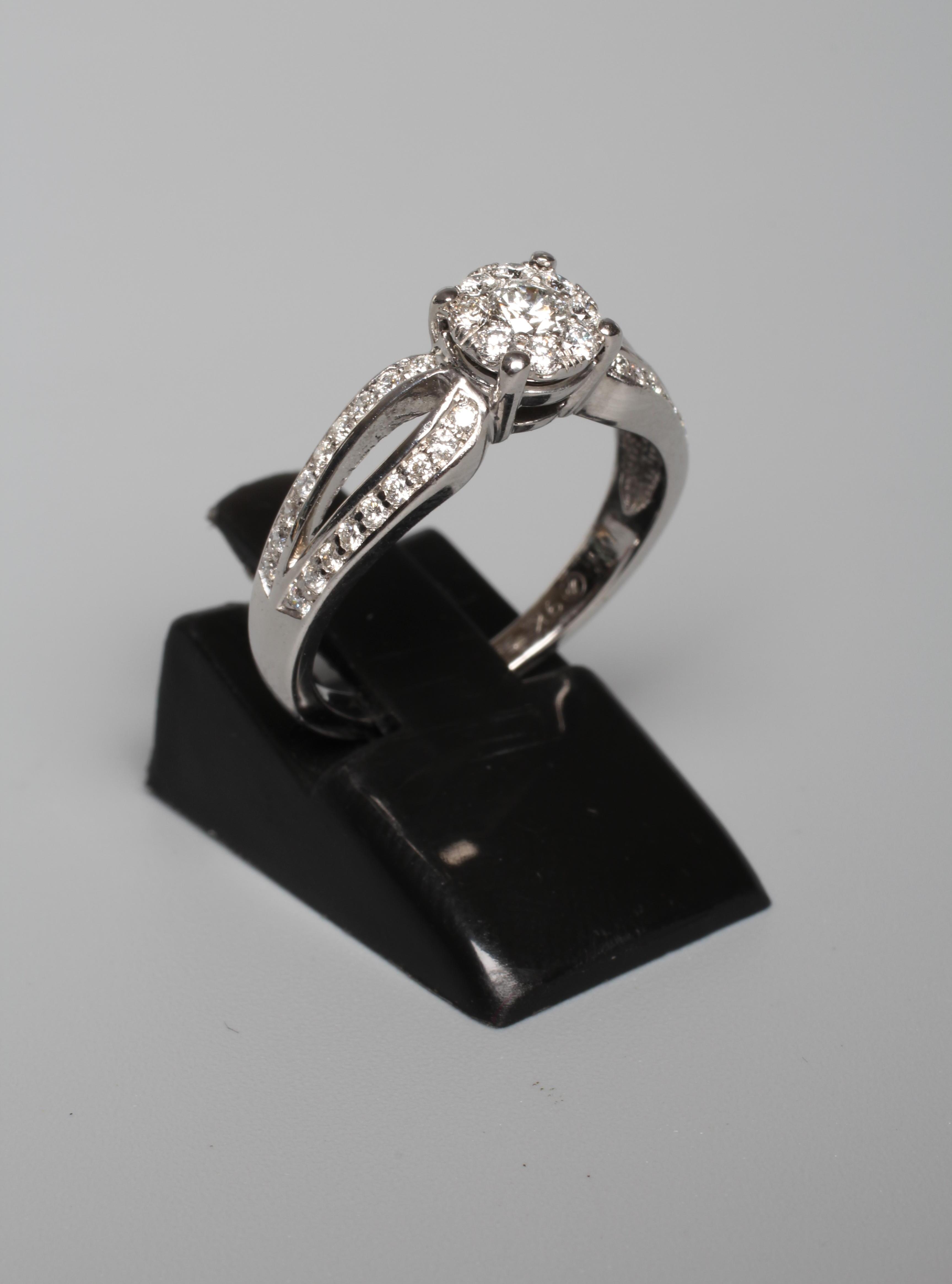 A DIAMOND DRESS RING, the central nine stone cluster claw set to split shoulders further pave set Image