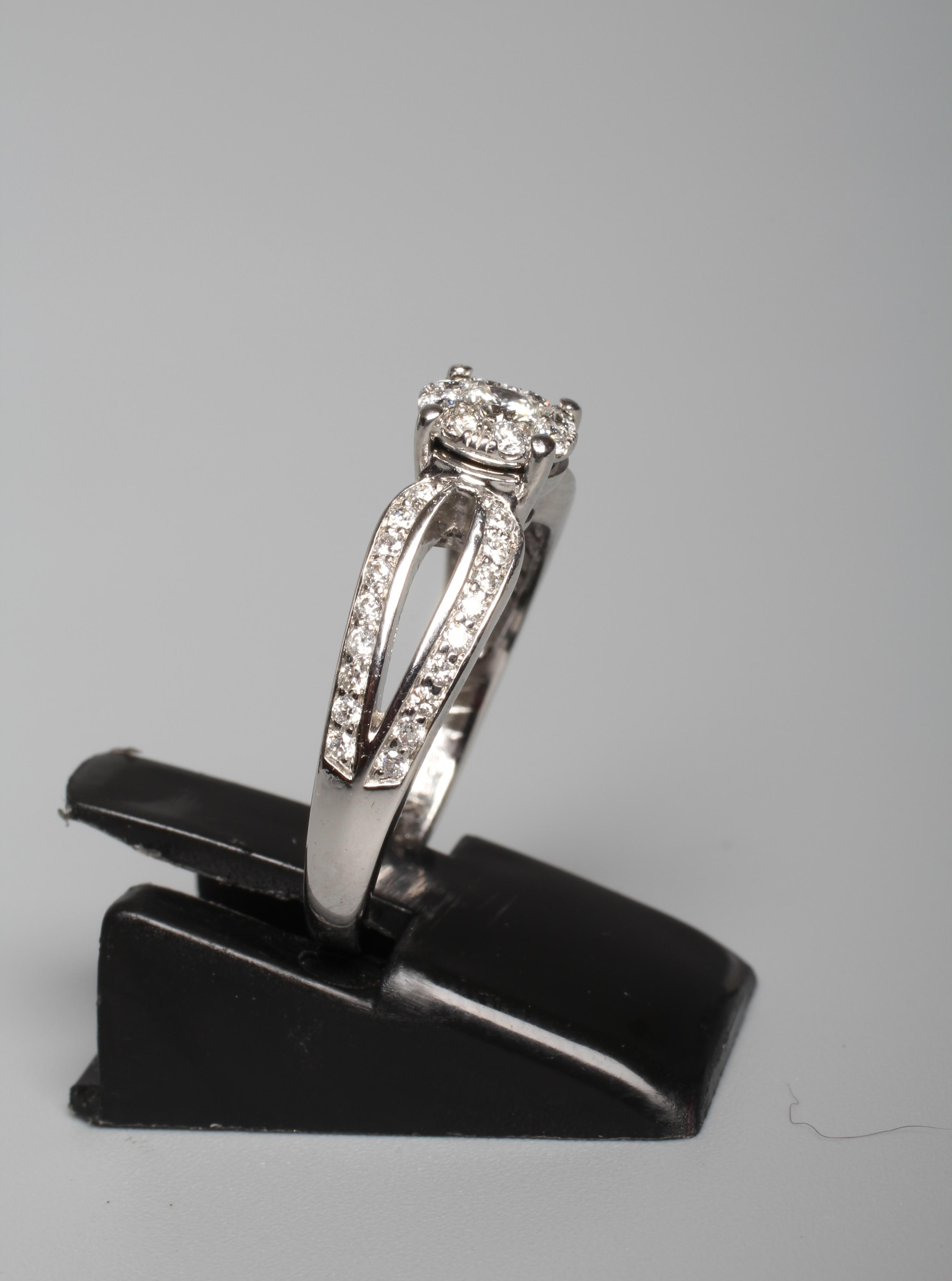 A DIAMOND DRESS RING, the central nine stone cluster claw set to split shoulders further pave set Image