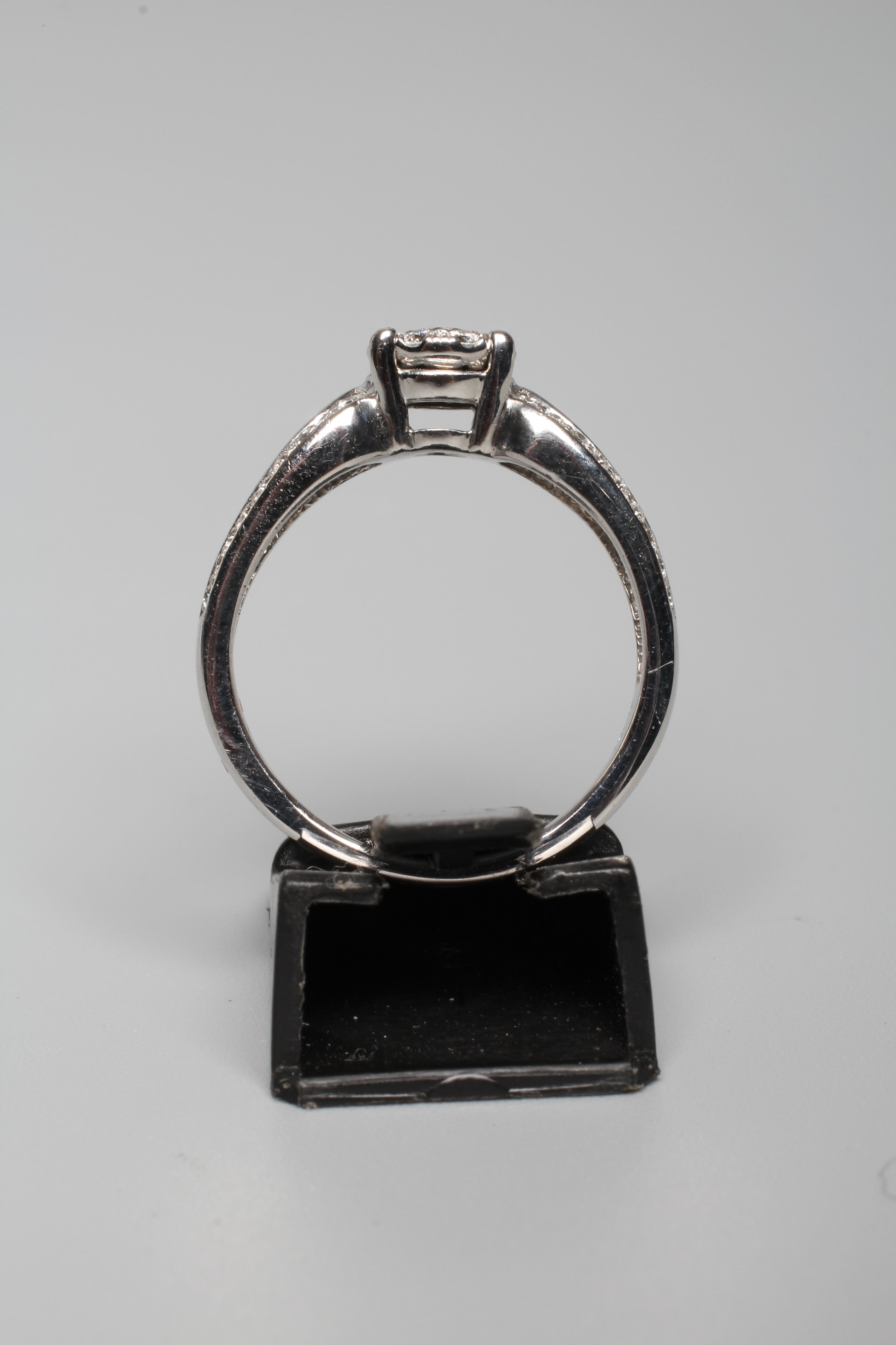 A DIAMOND DRESS RING, the central nine stone cluster claw set to split shoulders further pave set Image