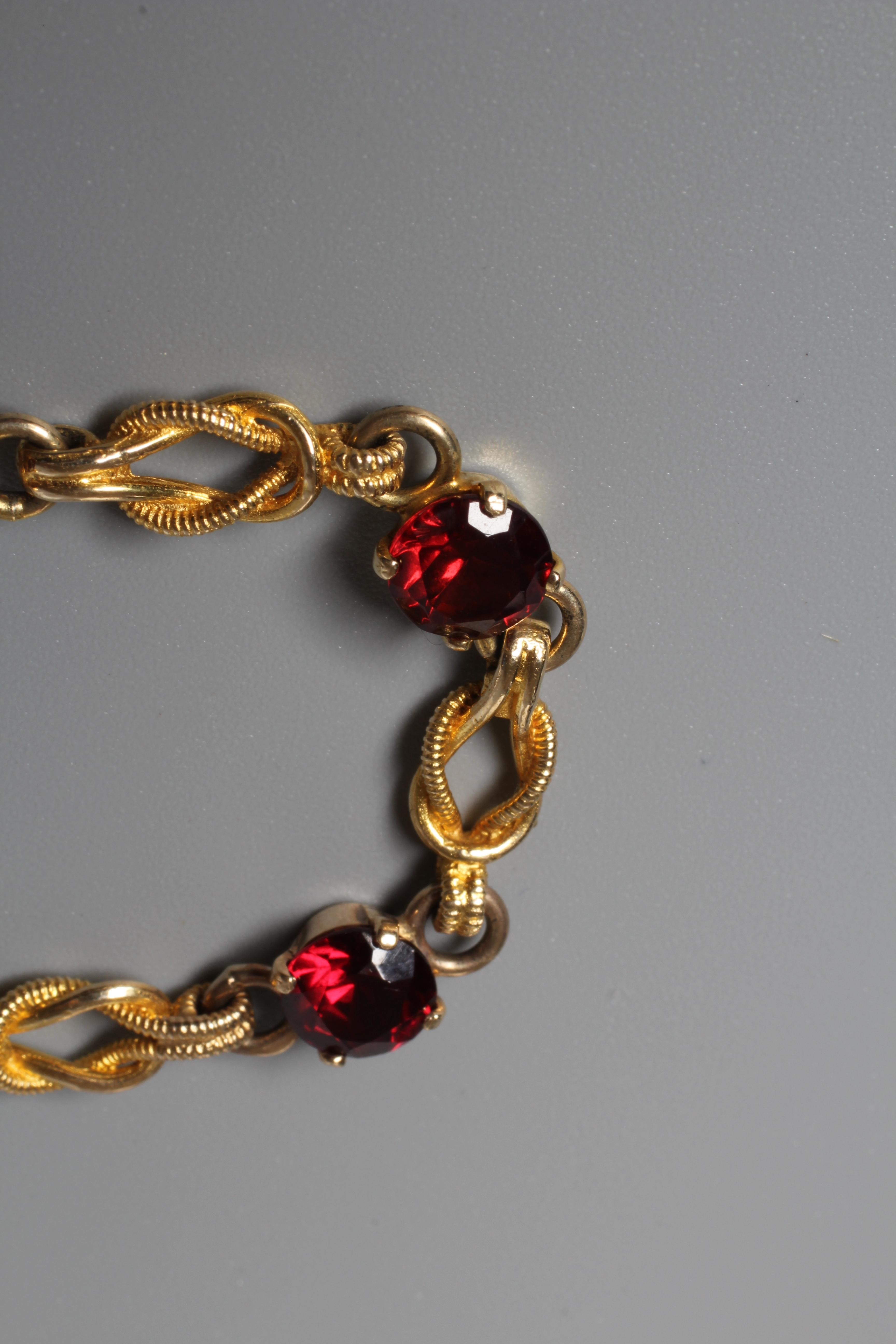 A GARNET BRACELET, the six facet cut circular stones claw set to knot links, the spring ring clasp Image