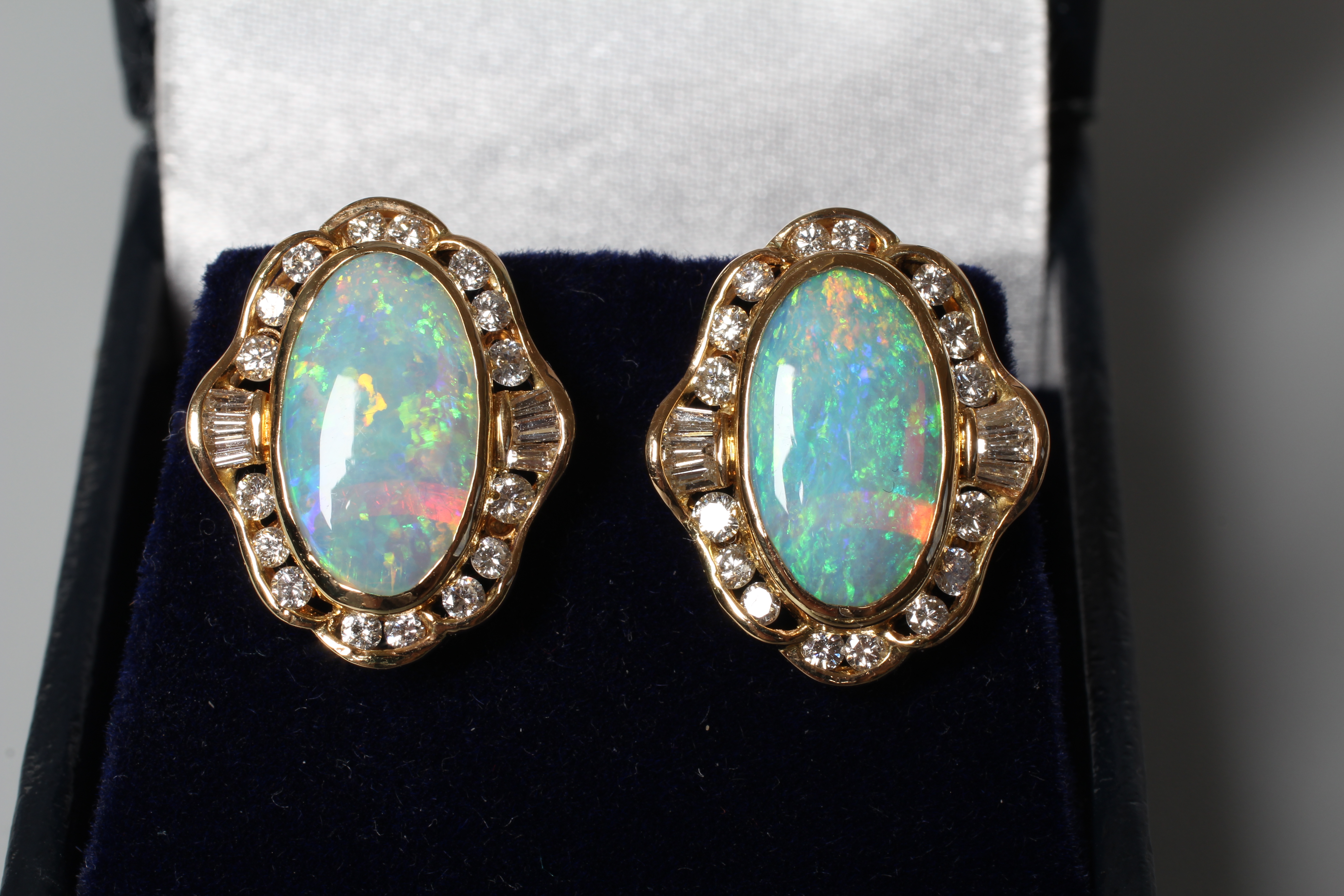 A PAIR OF OPAL AND DIAMOND CLUSTER EARRINGS, the oval polished cabochon opals bezel set to a border Image