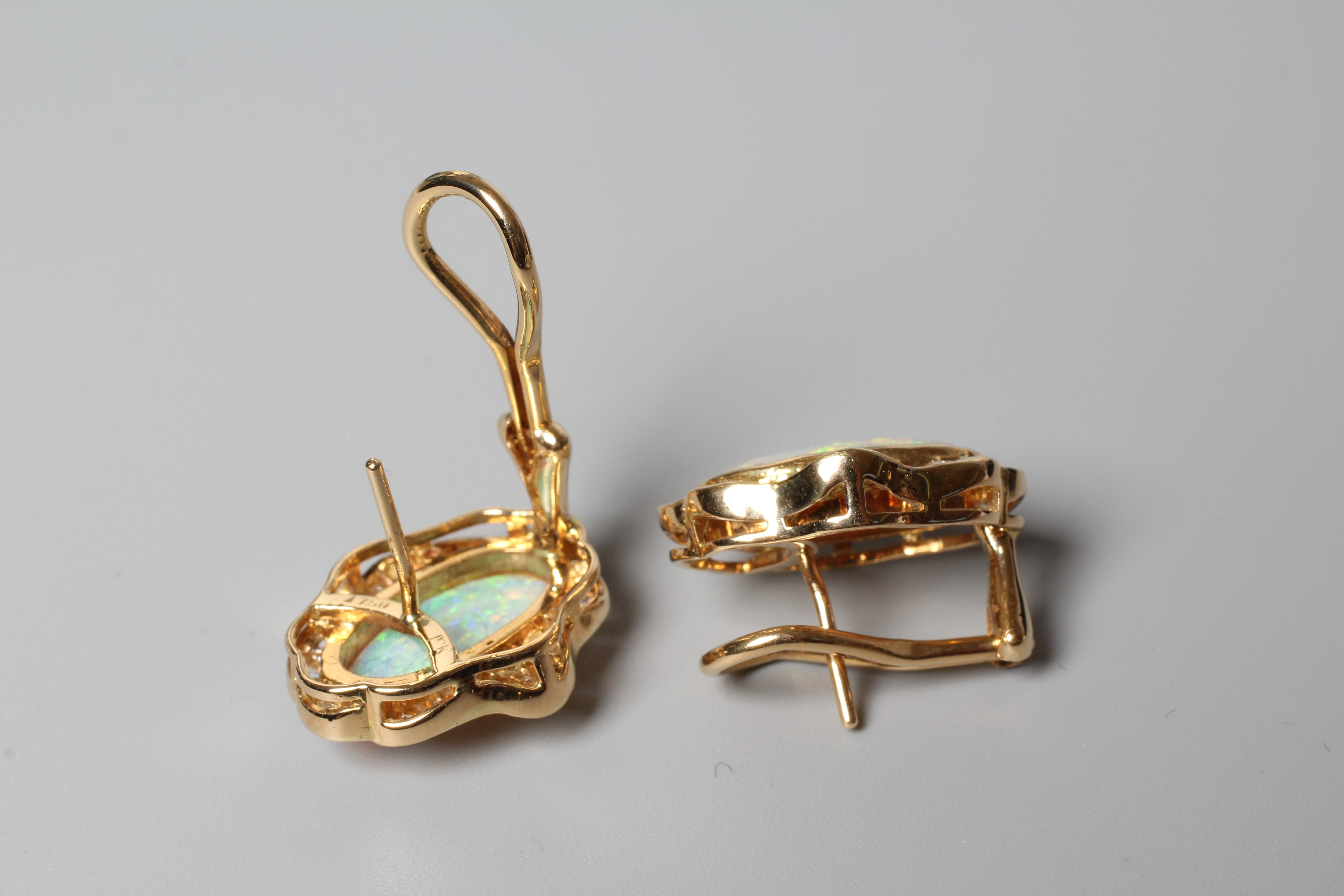 A PAIR OF OPAL AND DIAMOND CLUSTER EARRINGS, the oval polished cabochon opals bezel set to a border Image