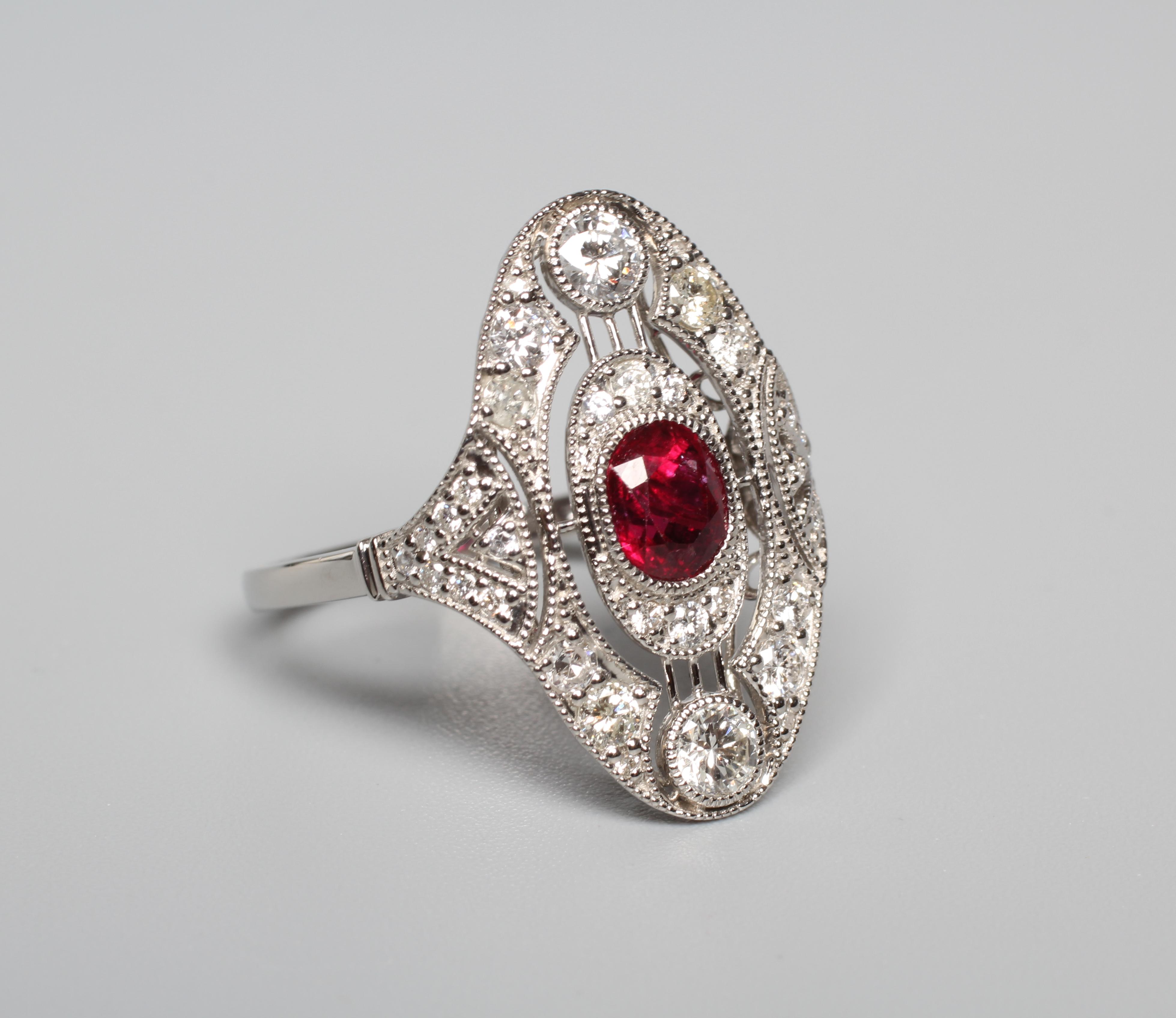 AN ART DECO STYLE RUBY AND DIAMOND PLAQUE RING, the central oval facet cut ruby collet set to an Image
