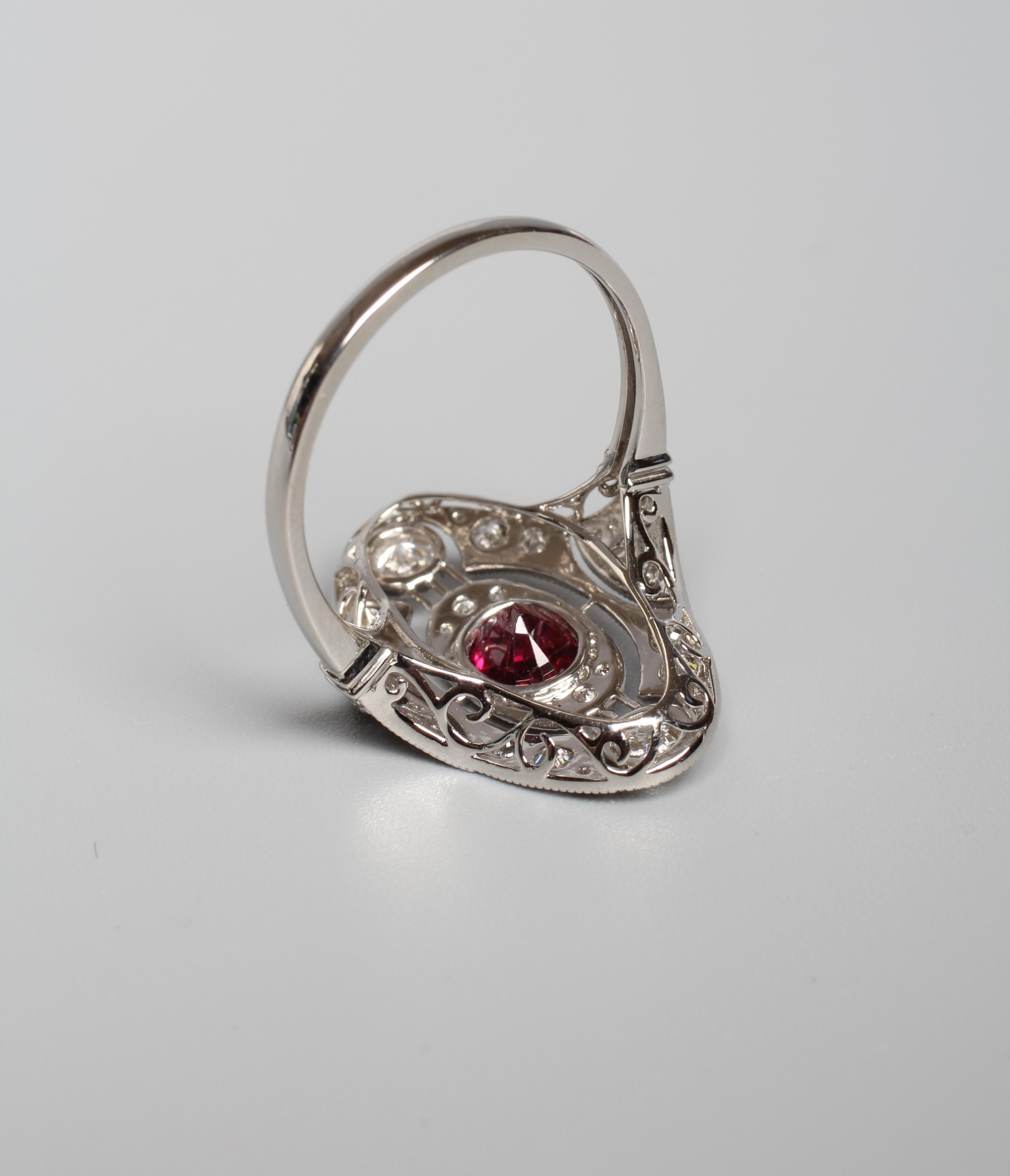 AN ART DECO STYLE RUBY AND DIAMOND PLAQUE RING, the central oval facet cut ruby collet set to an Image