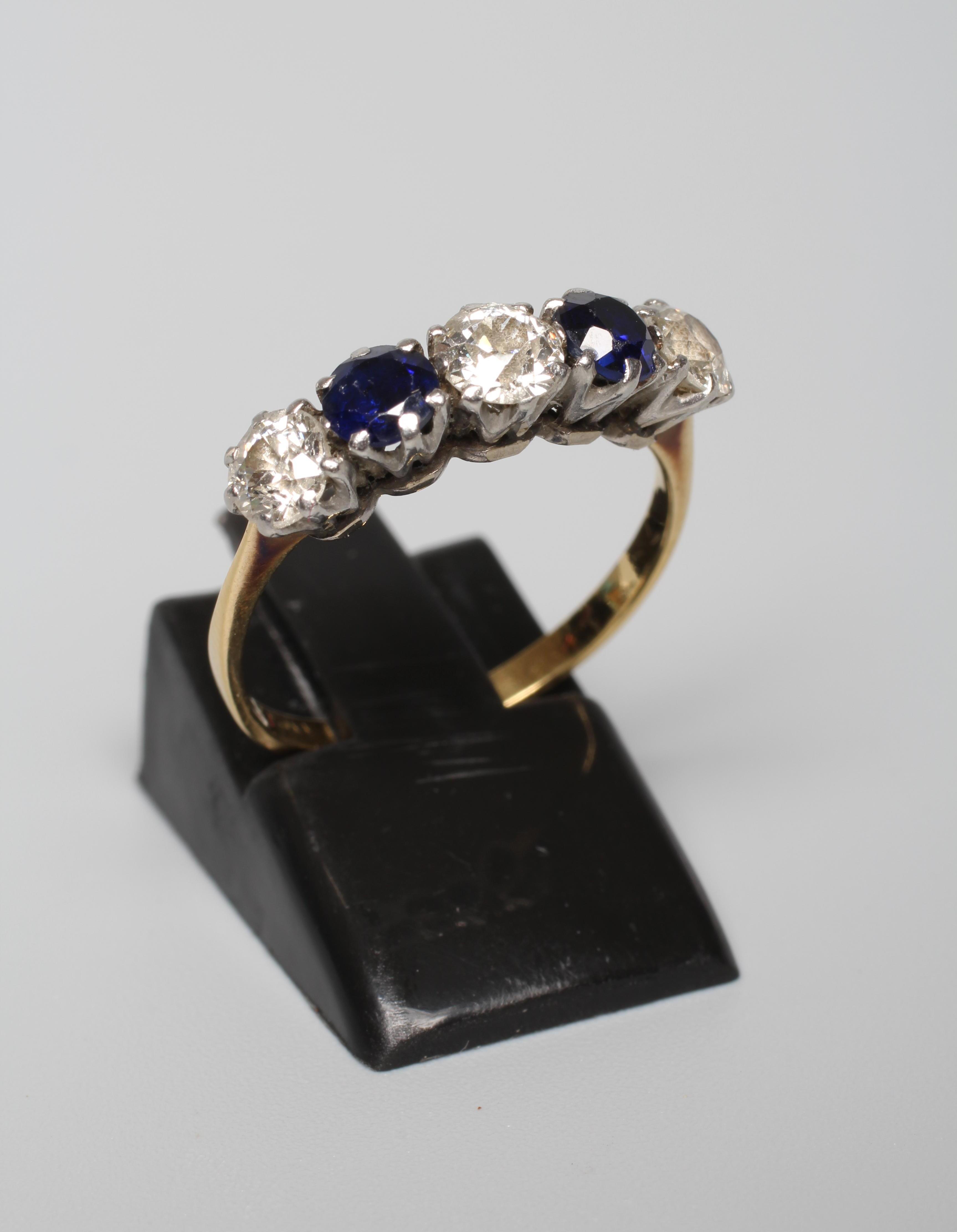 A FIVE STONE SAPPHIRE AND DIAMOND HALF HOOP RING, the stones claw set to a plain shank stamped 18ct Image