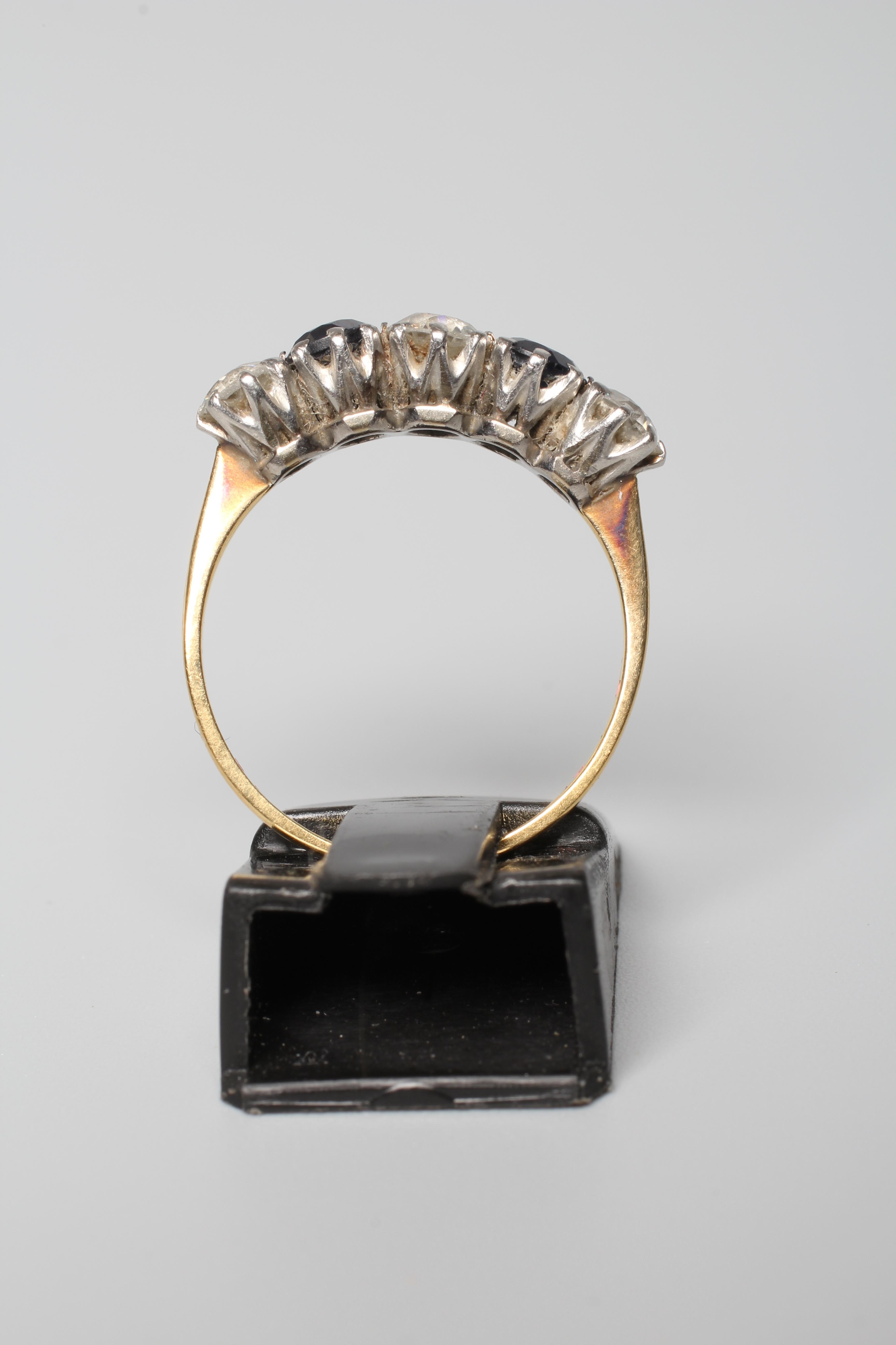 A FIVE STONE SAPPHIRE AND DIAMOND HALF HOOP RING, the stones claw set to a plain shank stamped 18ct Image