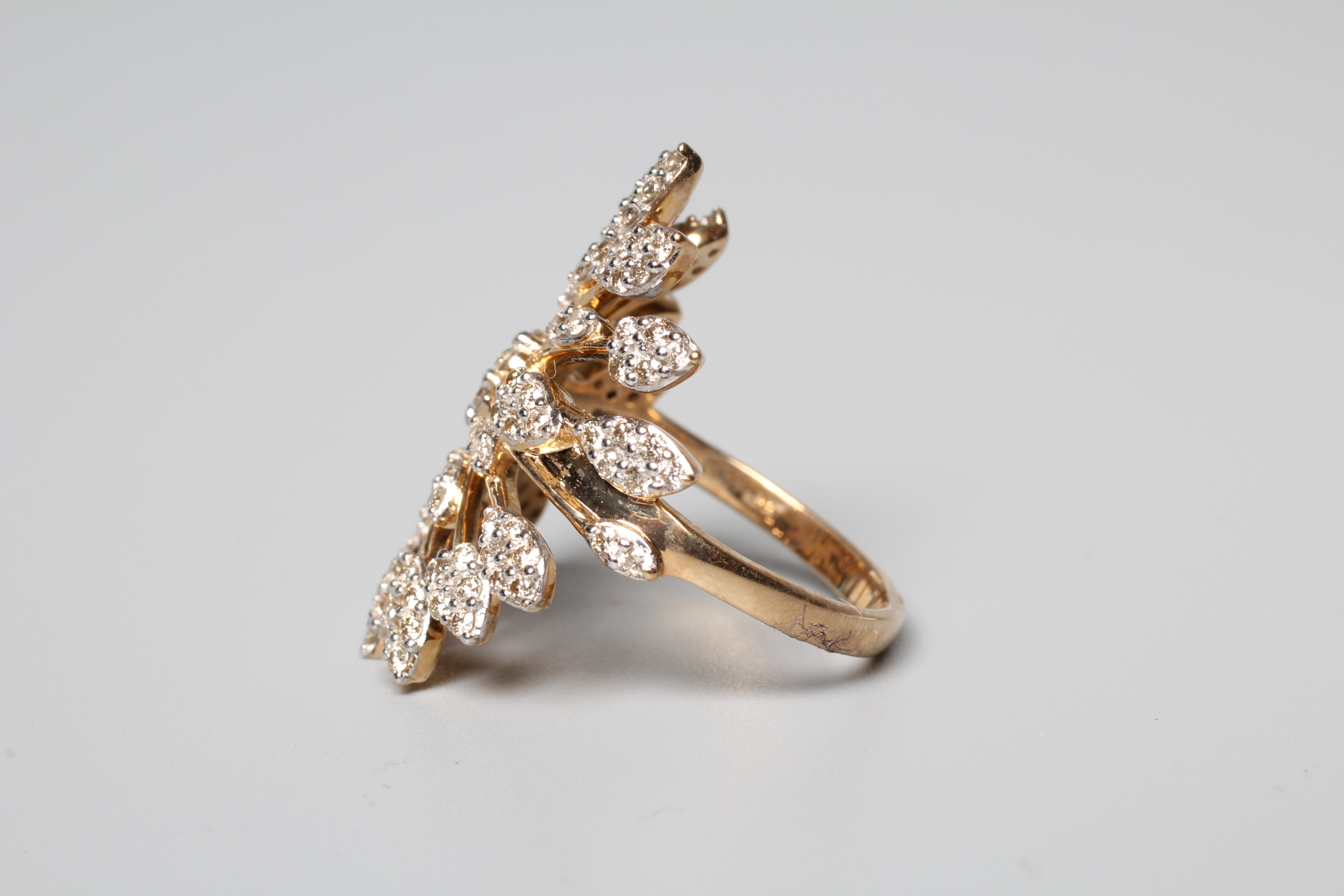 A DIAMOND STAR BURST RING, the round brilliants point set to a rose gold frame and plain shank, size Image
