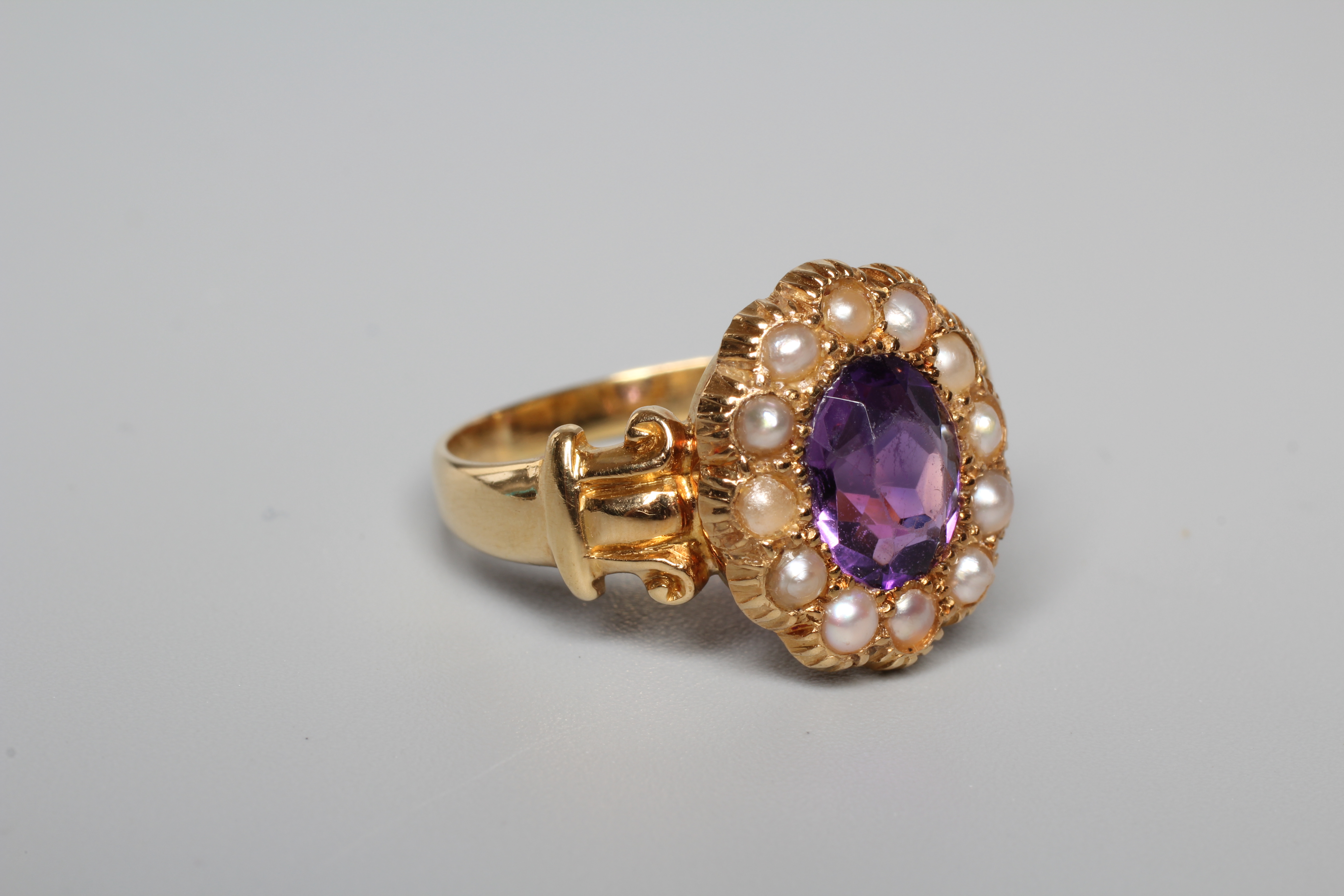 A LATE VICTORIAN AMETHYST AND SEED PEARL CUSTER RING, the oval facet cut amethyst claw set to a Image