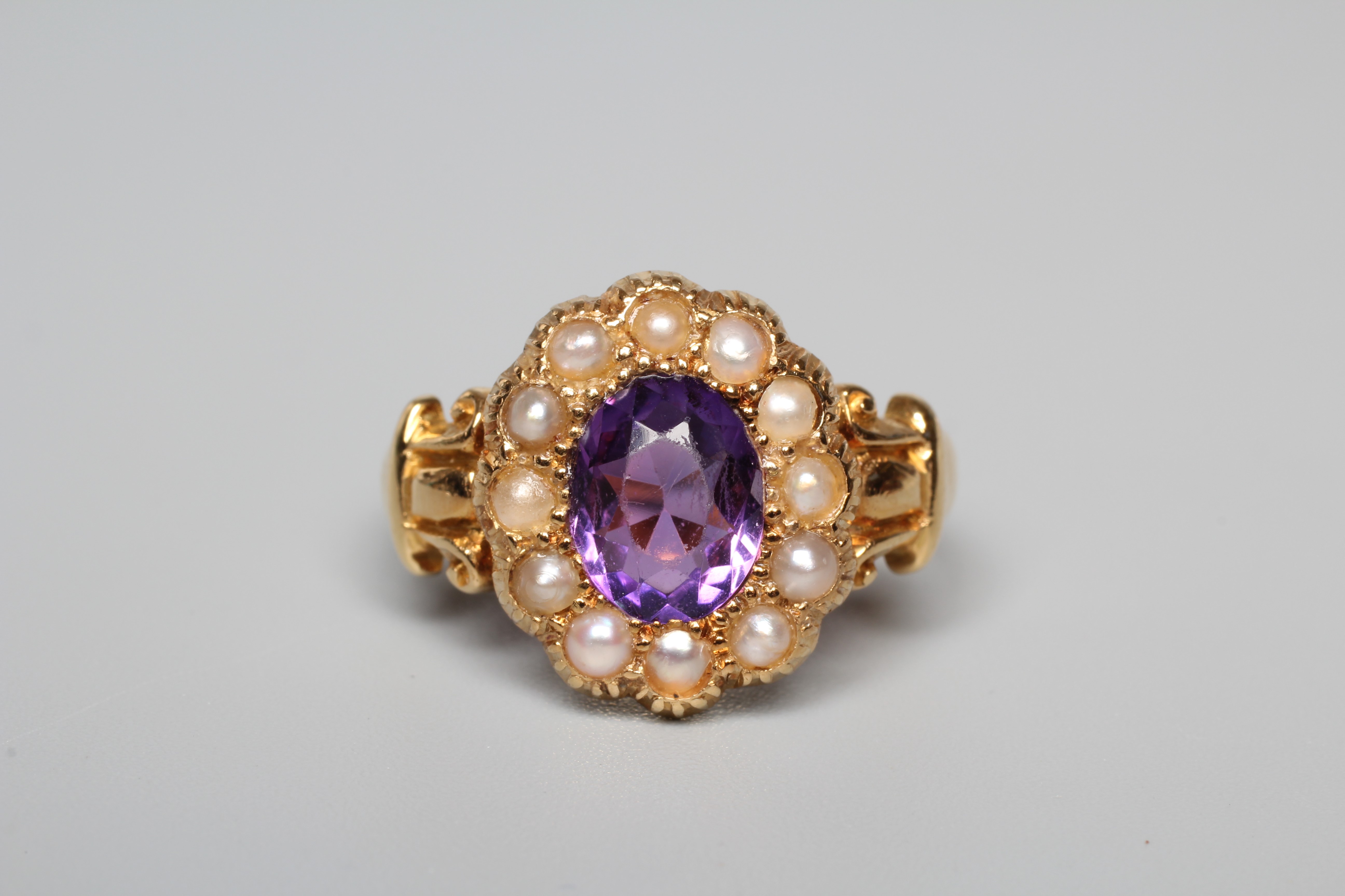 A LATE VICTORIAN AMETHYST AND SEED PEARL CUSTER RING, the oval facet cut amethyst claw set to a Image