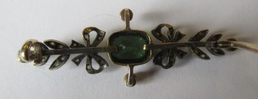 A VICTORIAN PERIDOT AND DIAMOND BROOCH, the facet cut oblong peridot open back collet set to rose Image