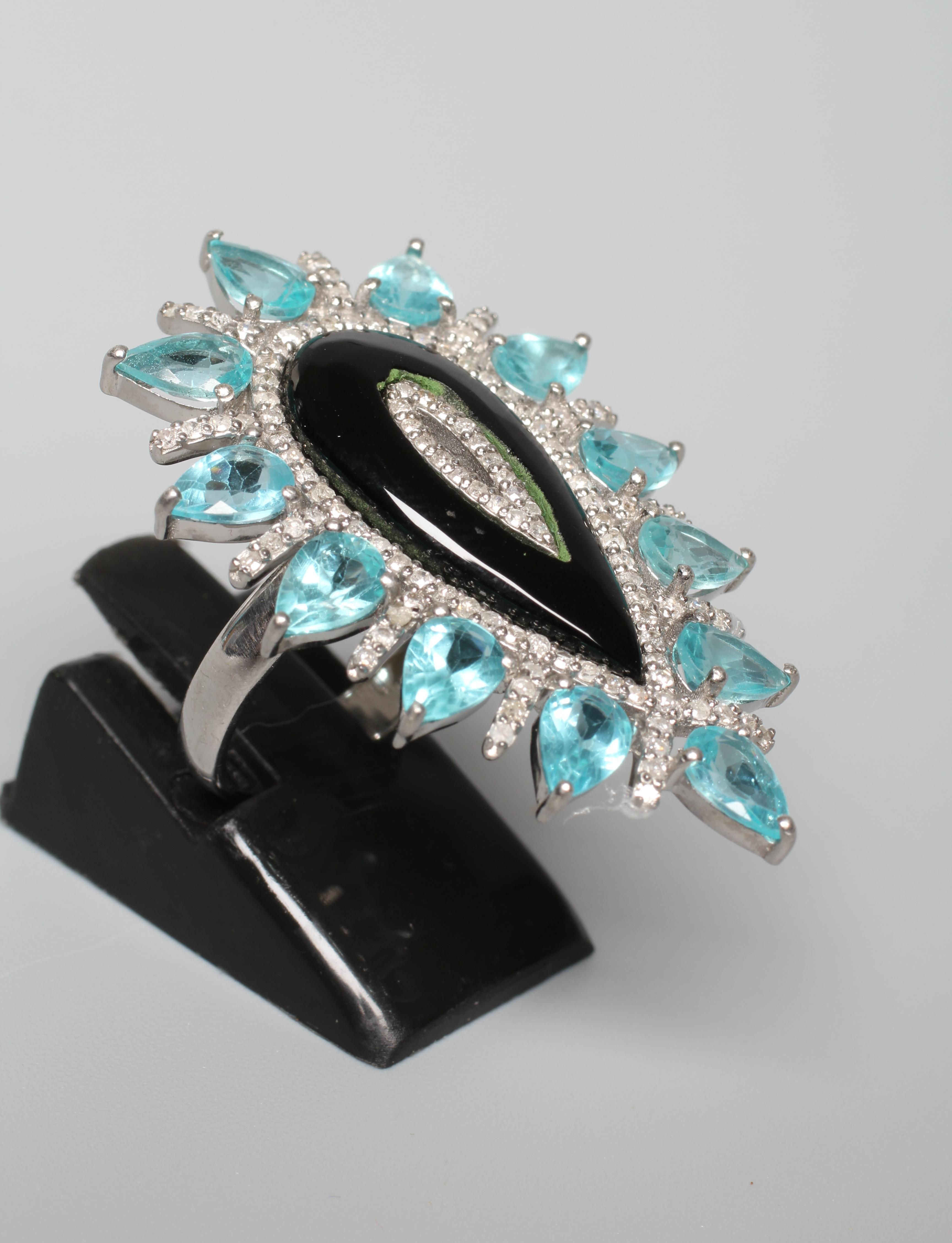 A LARGE DRESS RING, the central pear cut black onyx panel with diamond set borders and an outer Image