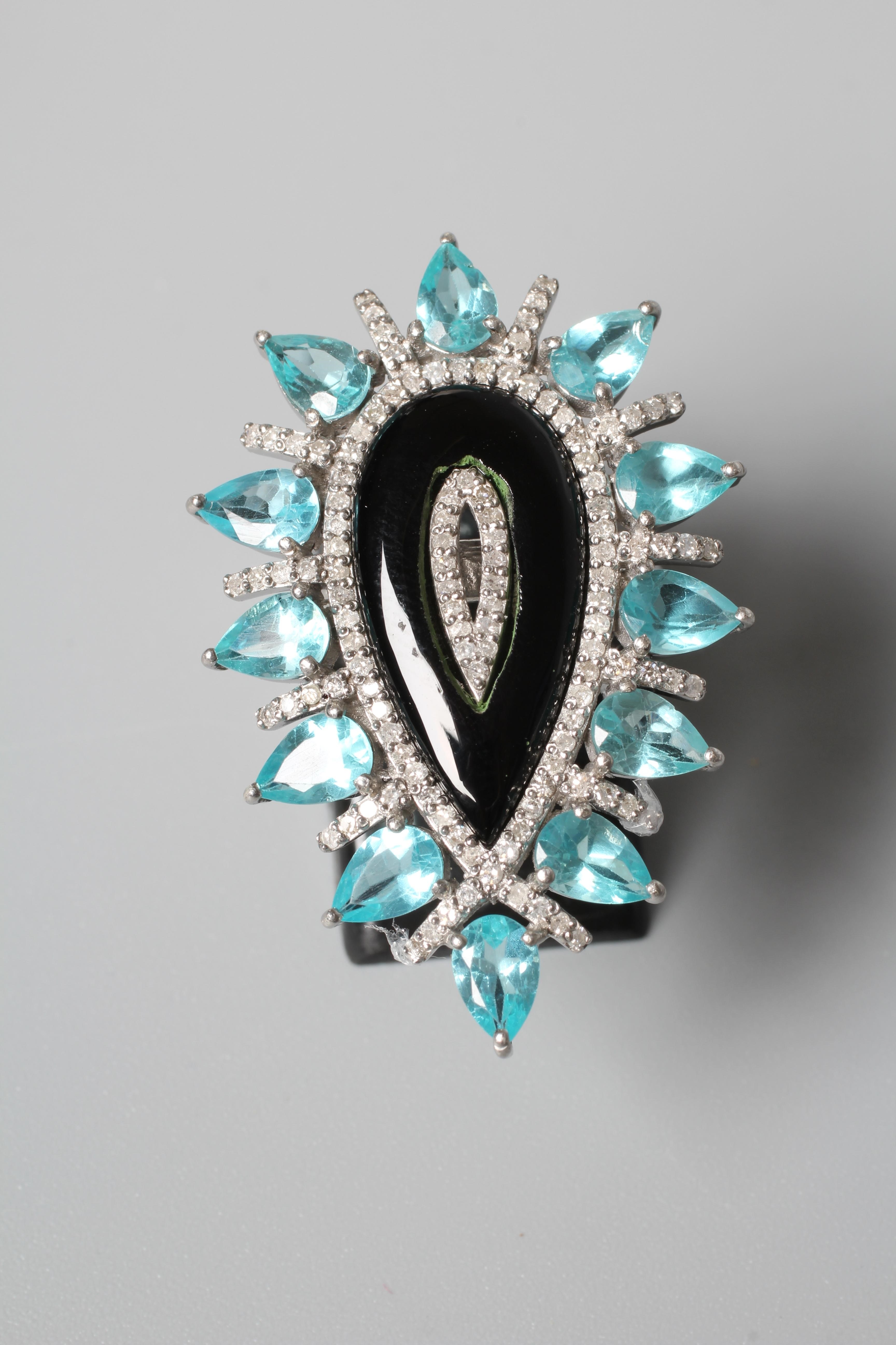A LARGE DRESS RING, the central pear cut black onyx panel with diamond set borders and an outer Image