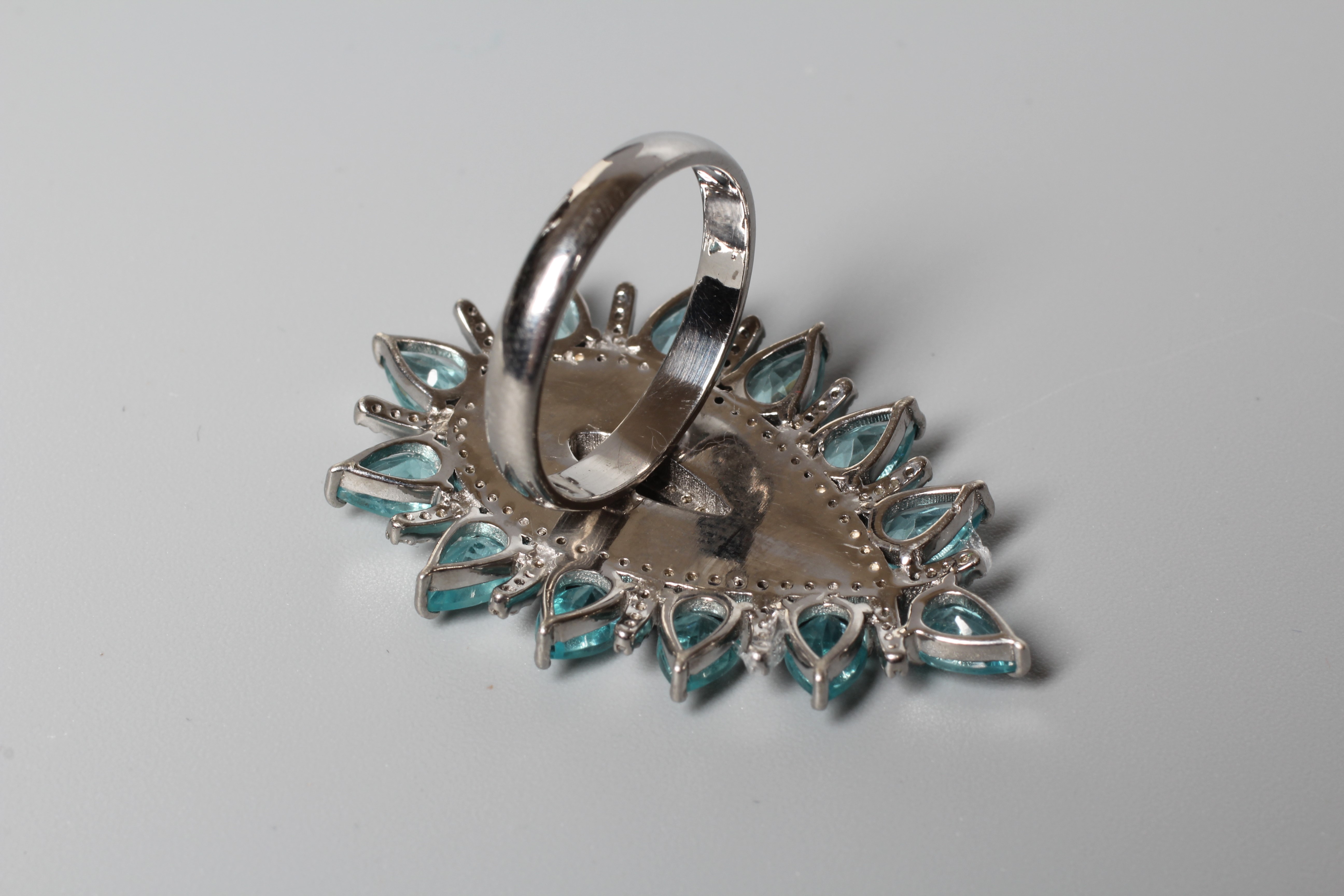 A LARGE DRESS RING, the central pear cut black onyx panel with diamond set borders and an outer Image