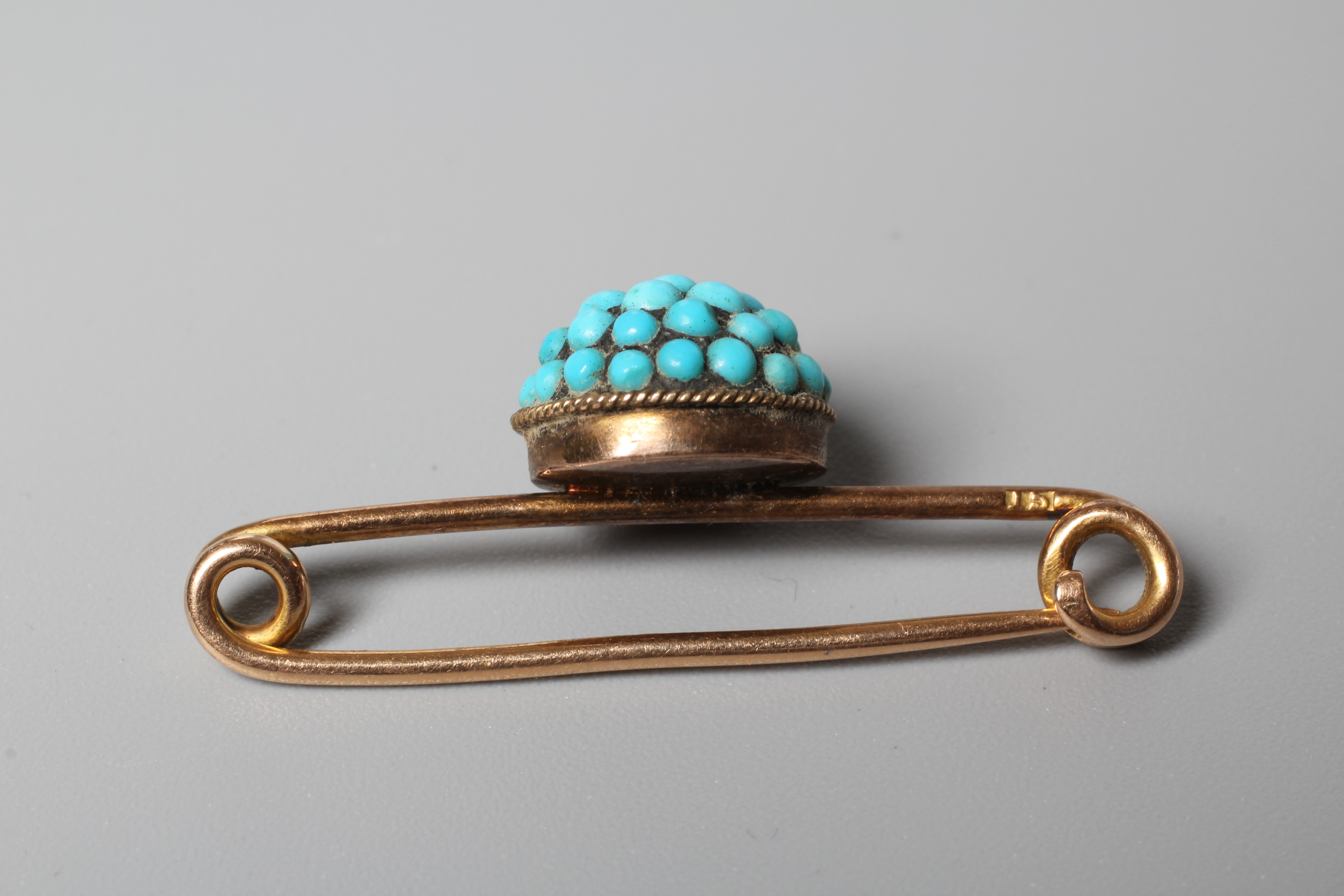 A LATE VICTORIAN BAR BROOCH centred by a turquoise bead set boss, stamped 15ct Image