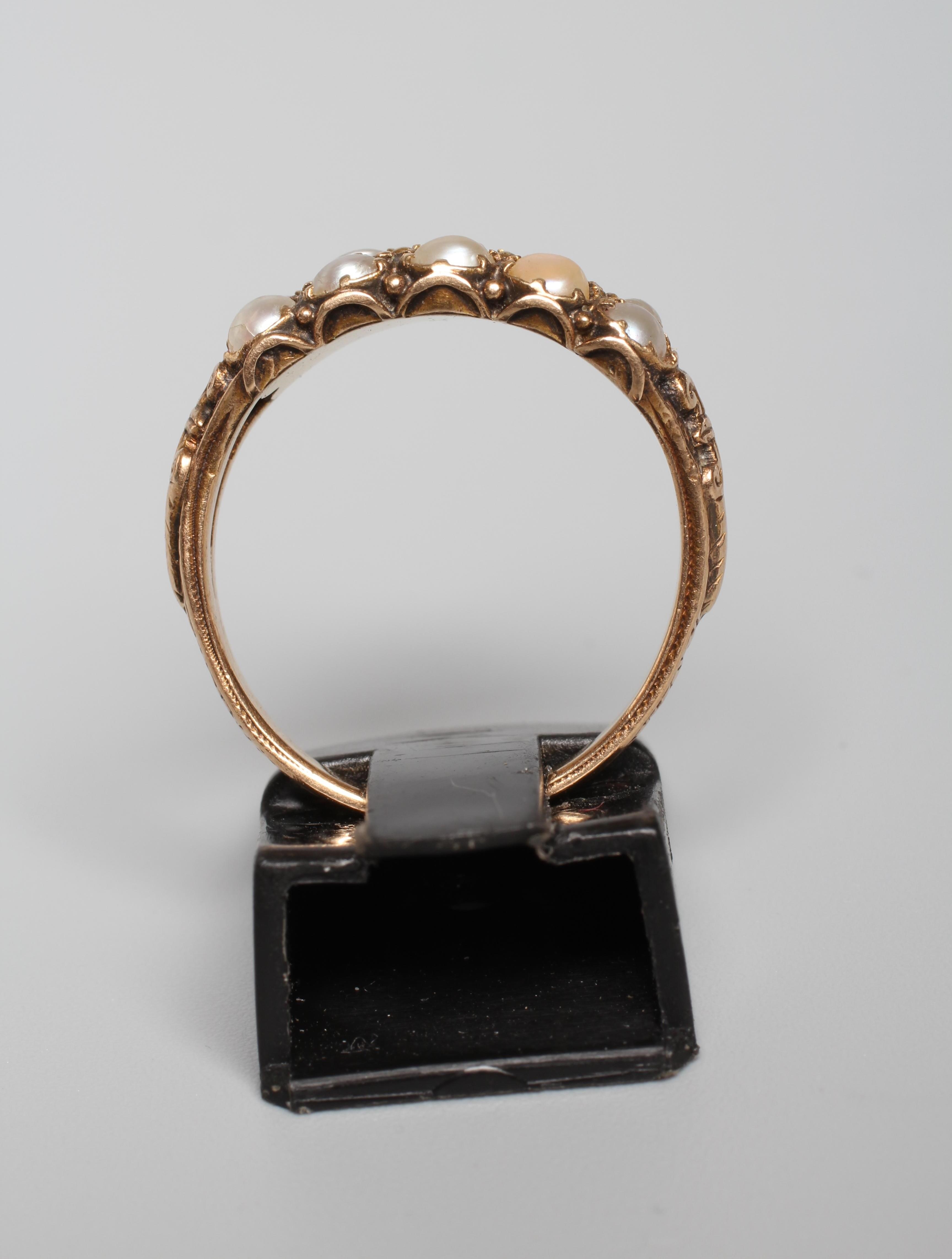 A VICTORIAN TWO ROW PEARL RING, the ten small pearls set in pairs to carved open shoulders and a Image