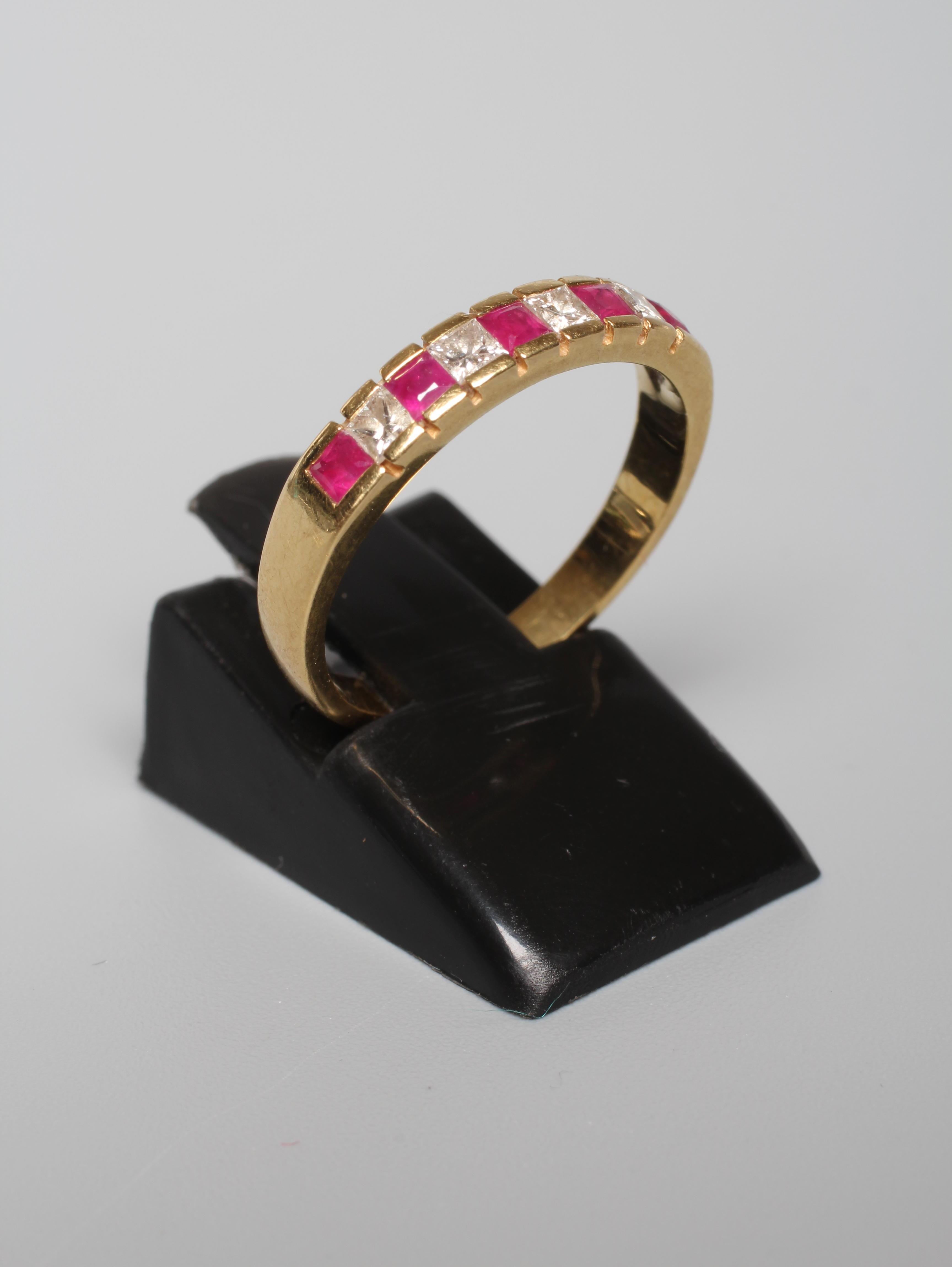 A RUBY AND DIAMOND NINE STONE HALF HOOP ETERNITY RING, the five calibre cut rubies and four Princess Image