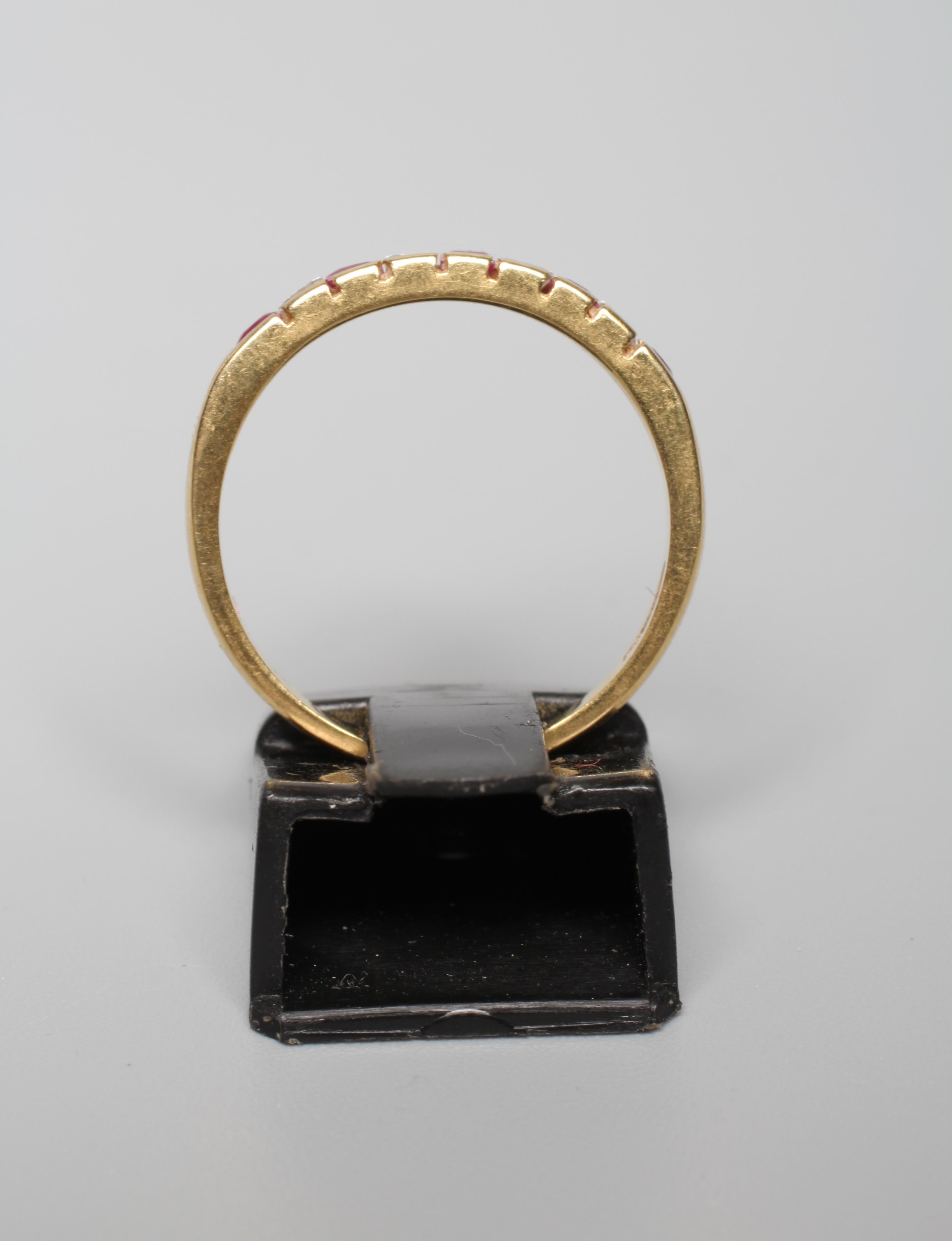 A RUBY AND DIAMOND NINE STONE HALF HOOP ETERNITY RING, the five calibre cut rubies and four Princess Image
