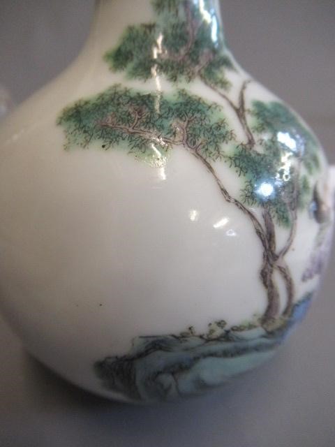 A CHINESE PORCELAIN SMALL BOTTLE VASE painted in coloured enamels with two figures seated beneath Image