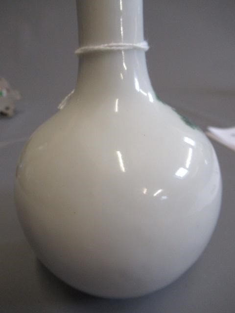 A CHINESE PORCELAIN SMALL BOTTLE VASE painted in coloured enamels with two figures seated beneath Image