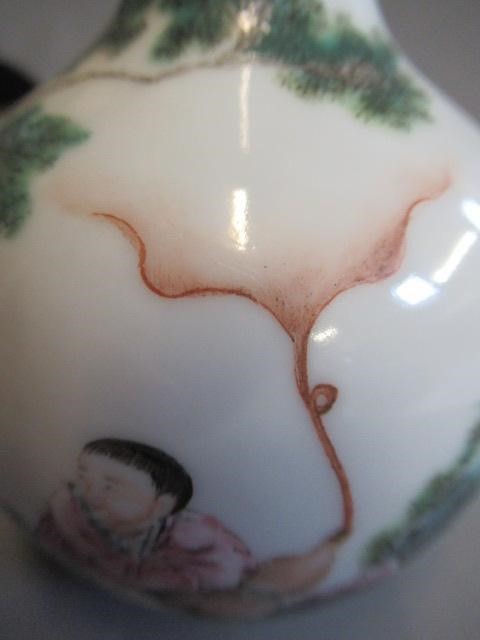 A CHINESE PORCELAIN SMALL BOTTLE VASE painted in coloured enamels with two figures seated beneath Image