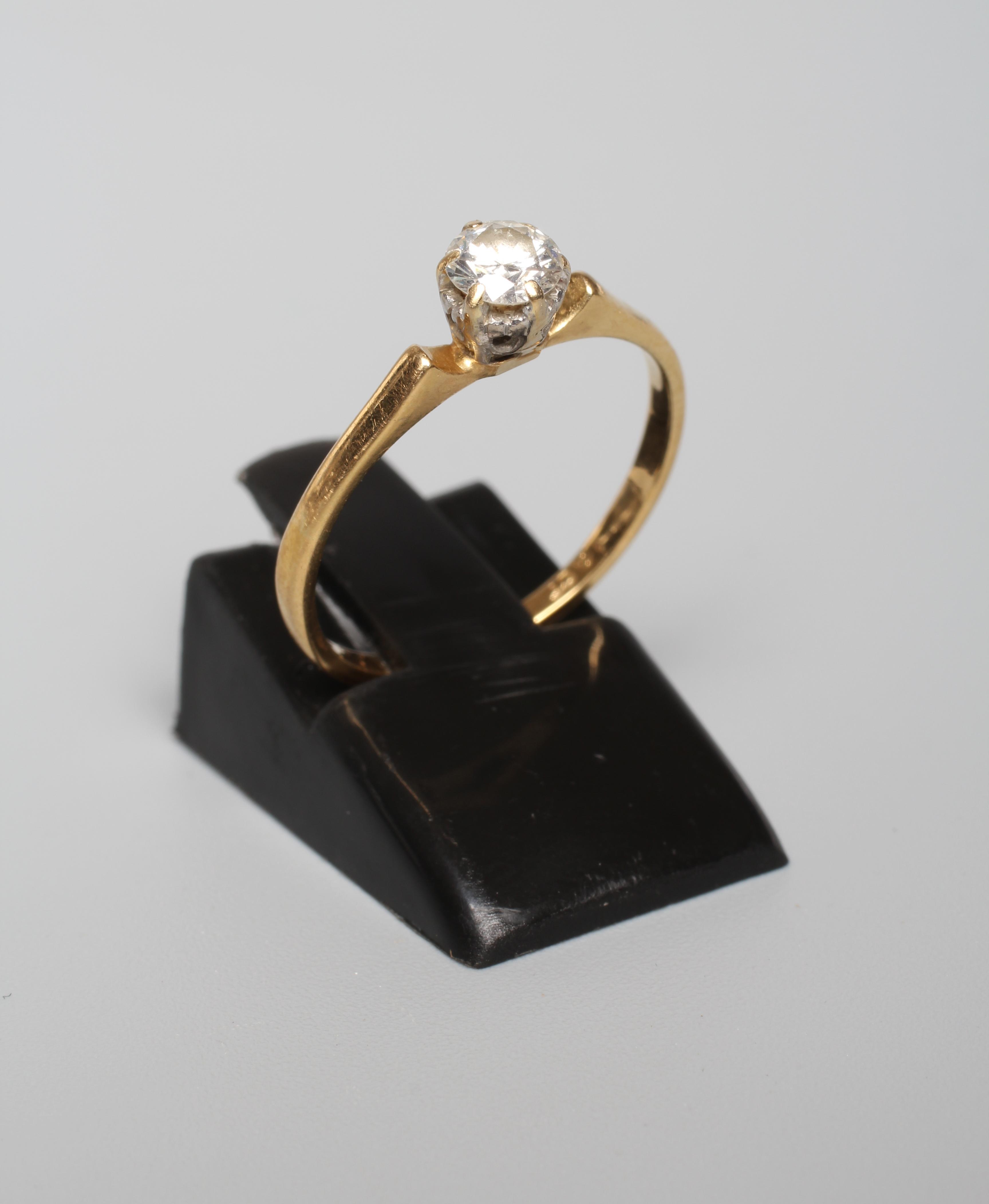 A SOLITAIRE DIAMOND RING, the old brilliant cut stone of approximately 0.4cts, claw set to a plain Image