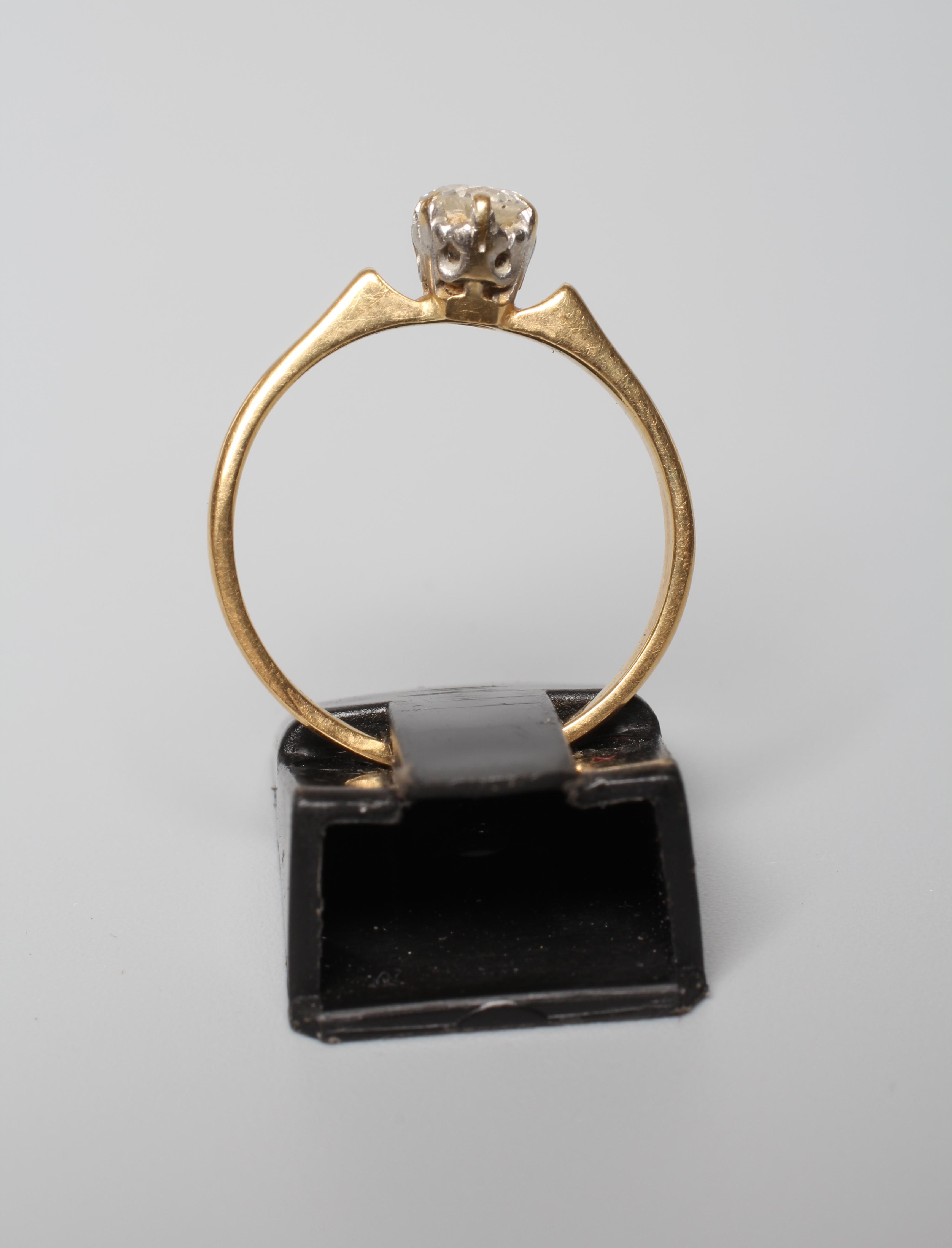 A SOLITAIRE DIAMOND RING, the old brilliant cut stone of approximately 0.4cts, claw set to a plain Image