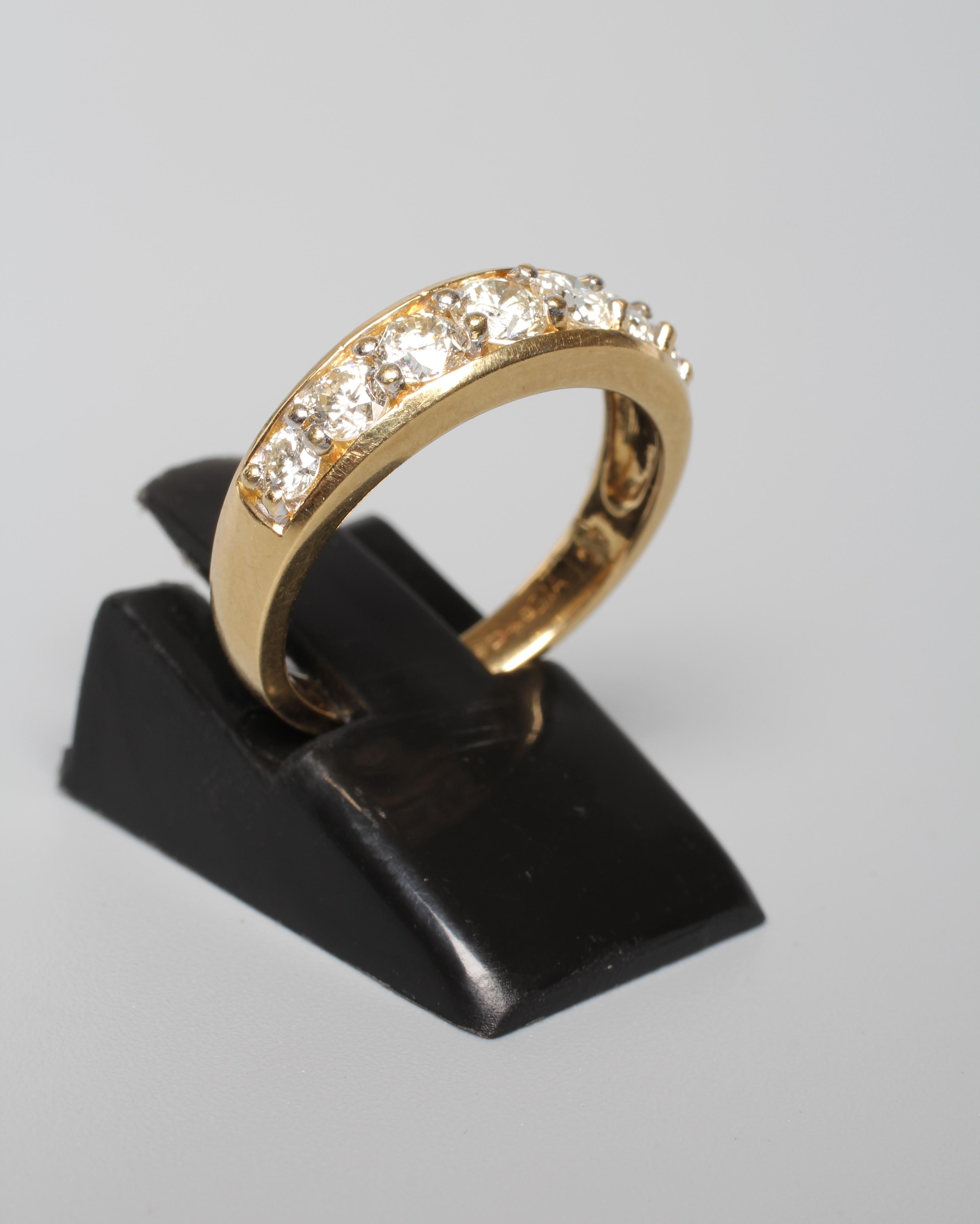 A SEVEN STONE DIAMOND HALF HOOP RING, the graduated round brilliants point set to a plain 18ct gold Image